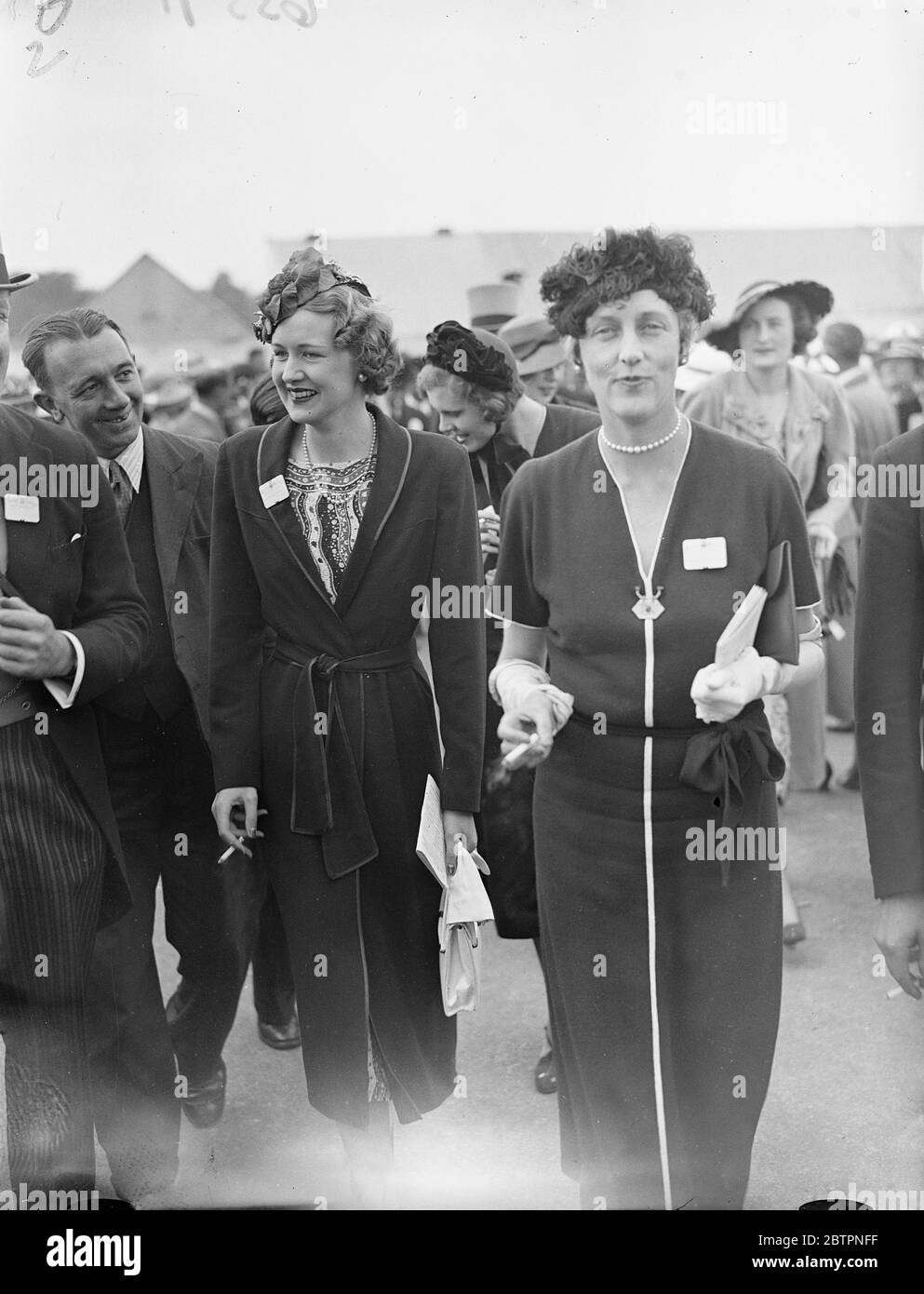 Hat novelties at Ascot. Two novel hat styles seen at Ascot on the opening day of the meeting. 15 June 1937 Stock Photo