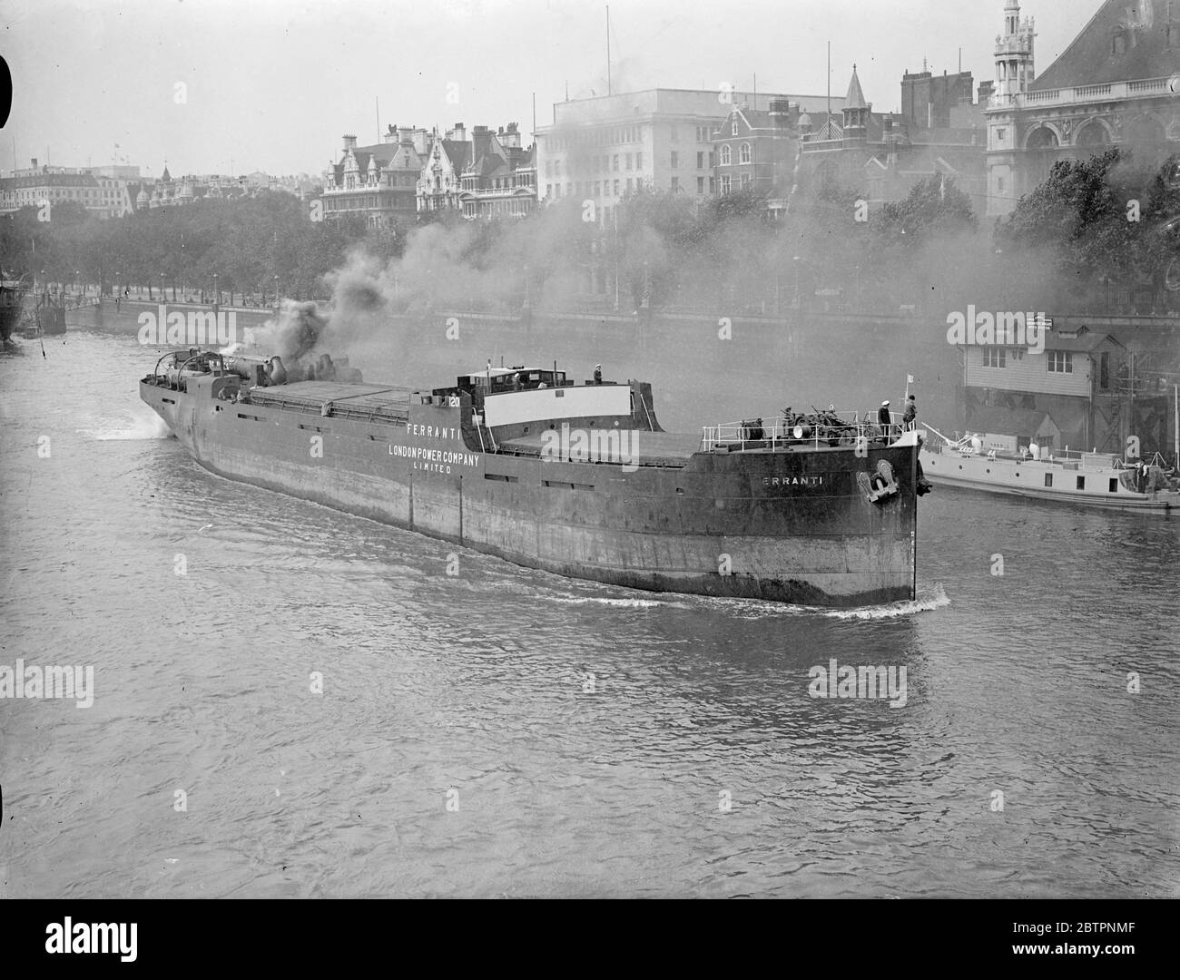 Fire ship! Clouds of smoke rising from the steamer 'Ferranti'give the impression that she is on fire in the River Thames. But the slight crowds were caused as she lowered her final to pass on the Blackfriars Bridge. 25 September 1937 Stock Photo