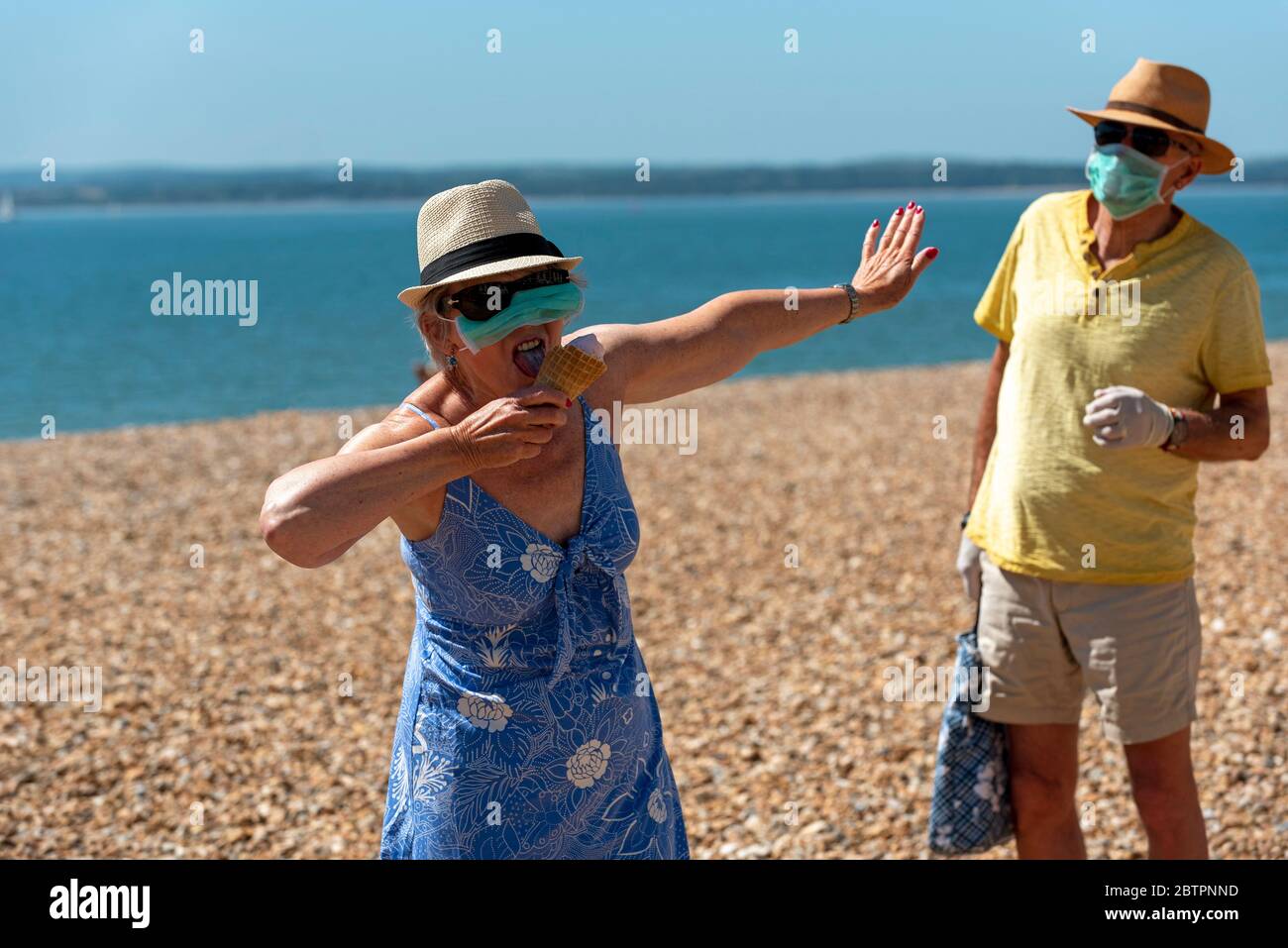 Southsea, Portsmouth, Southern England, UK. May 2020. Woman eating ice cream whilst wearing a