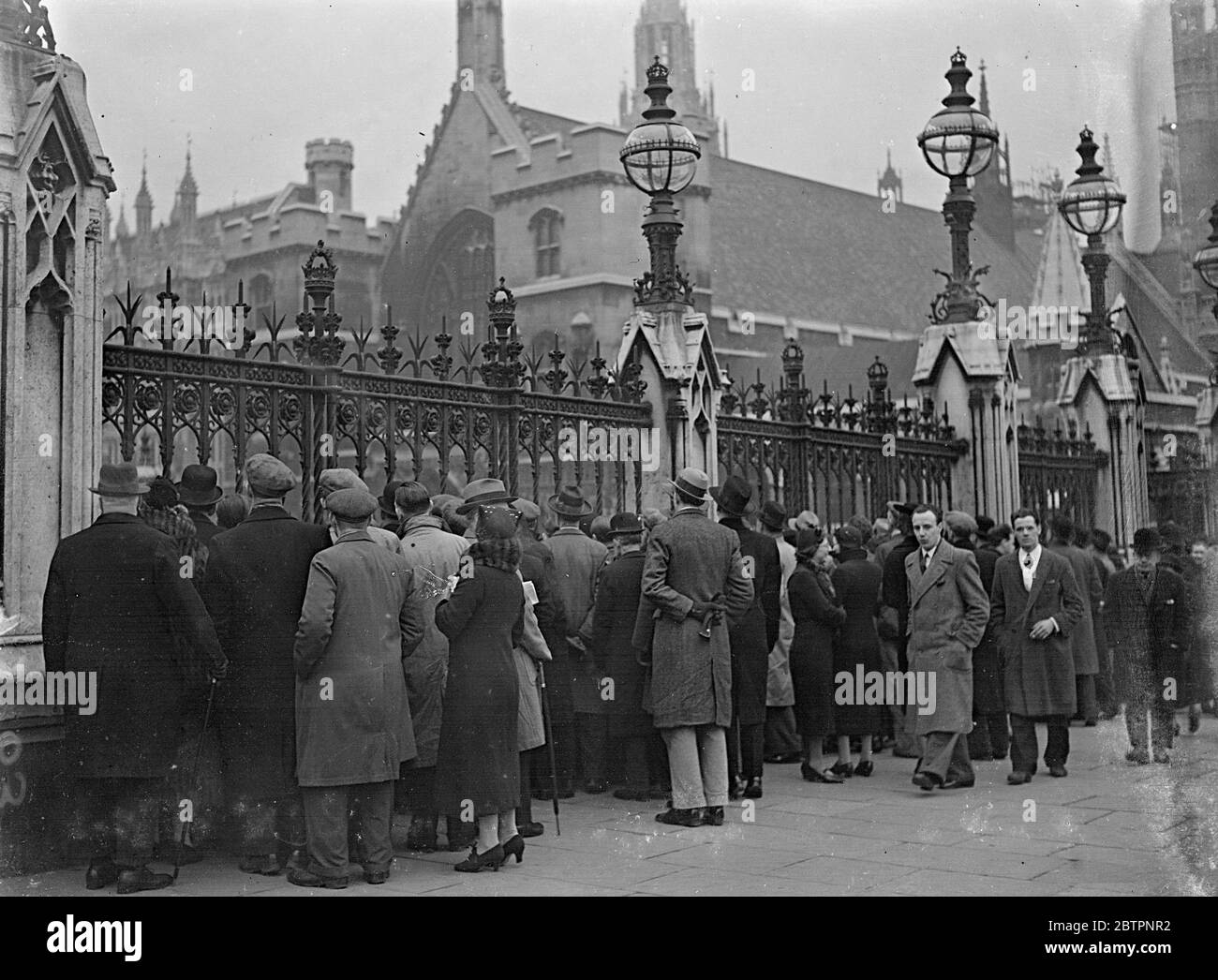 Through the railings. Crowds outside Parliament during Censure debate. An interested crowd peering through the railings at the Houses of Parliament as the House of Commons debated the Socialist vote of censure. 22 February 1938 Stock Photo