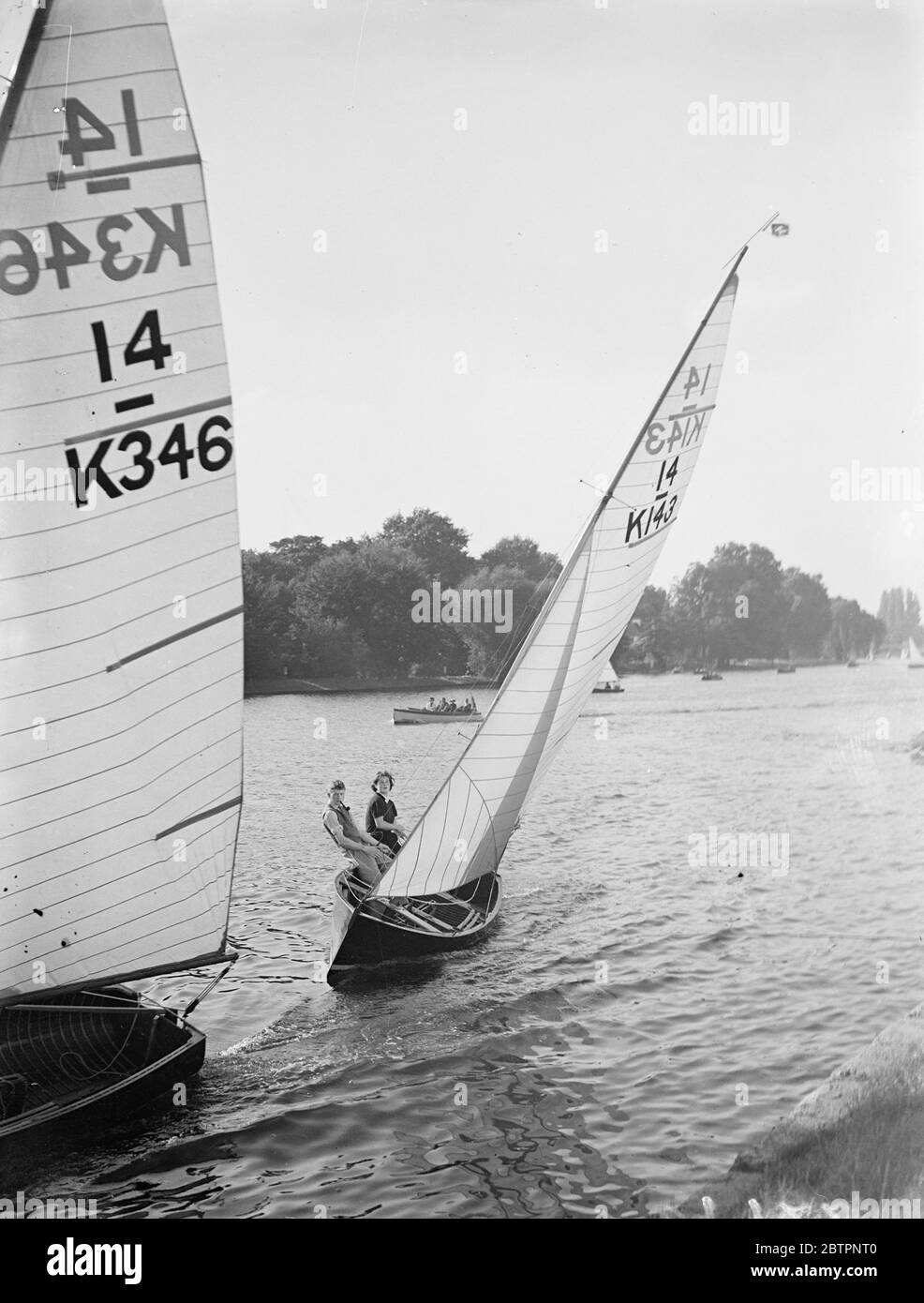 Yachting girls race in Teddington. Yachting girls, sailing, 14 feet international class craft, competed in the ladies race of the Tamesis Club races on the Thames at Teddington today (Sunday). Photo shows, a yacht healing over during the ladies race. 26 September 1937 Stock Photo