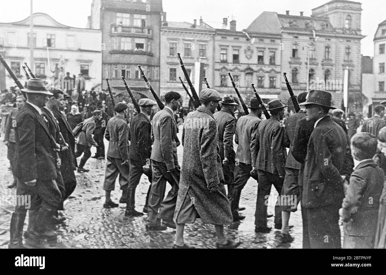 Poland takes over Teschen. A Polish army of occupation is now in possession at Teschen, the district which was ceded to Poland by Czechoslovakia in compliance with the Polish ultimatum. The occupation followed that of the Sudetenland by Germany. Photo shows, men of the Polish 'Free Corps' marching through Teschen , with rifles, though in civilian dresses the Polish forces occupied the city. . 4 October 1938 Stock Photo