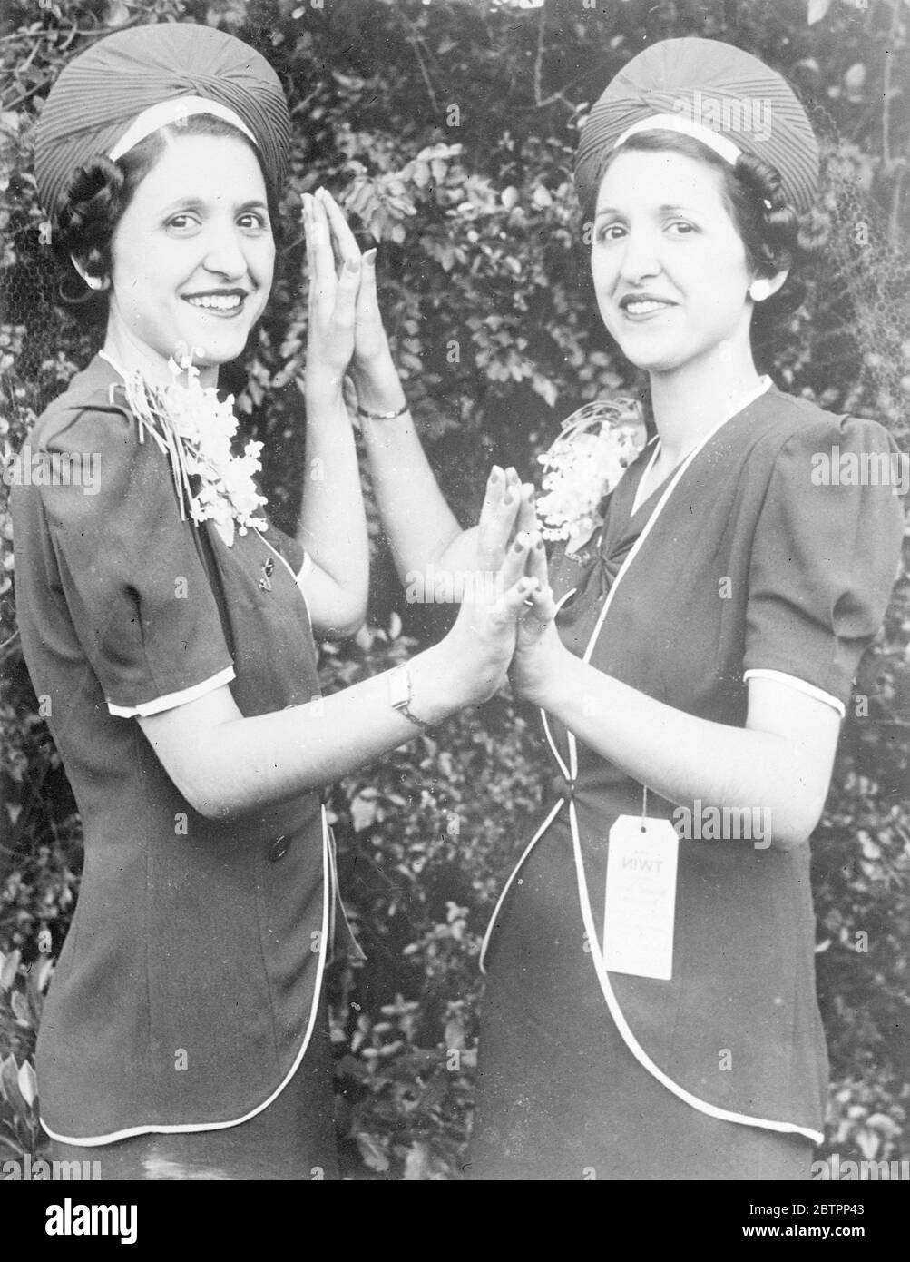 Twins beat the judge. Because they couldn't tell them apart, judges at the international Twin Convention in Chicago, Illinois, admitted defeat and awarded first prize and title of 'Most Identical Twins' to Virginia (left) and Ann Maenza of Birmingham, Alabama. The twins are 21 years old, and even their friends can't identify them. 5 September 1938 Stock Photo