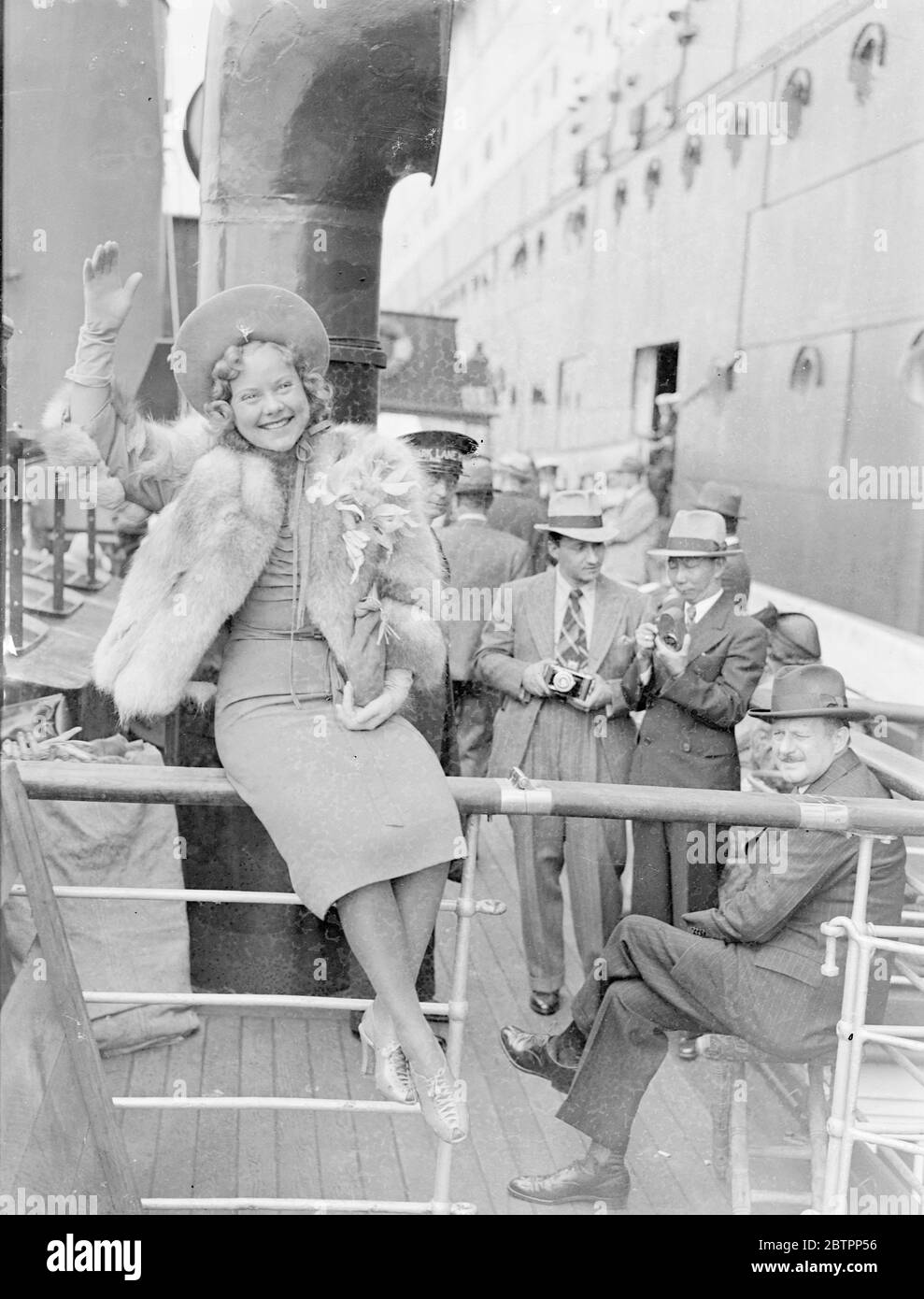 Sonja Henie arrives from America. Miss Sonja Henie, the skating film actress, arrived at Southampton on the liner 'Normandie' from America. Photo shows, Sonja Henie waving on arrival at Southampton. 4 July 1938 Stock Photo