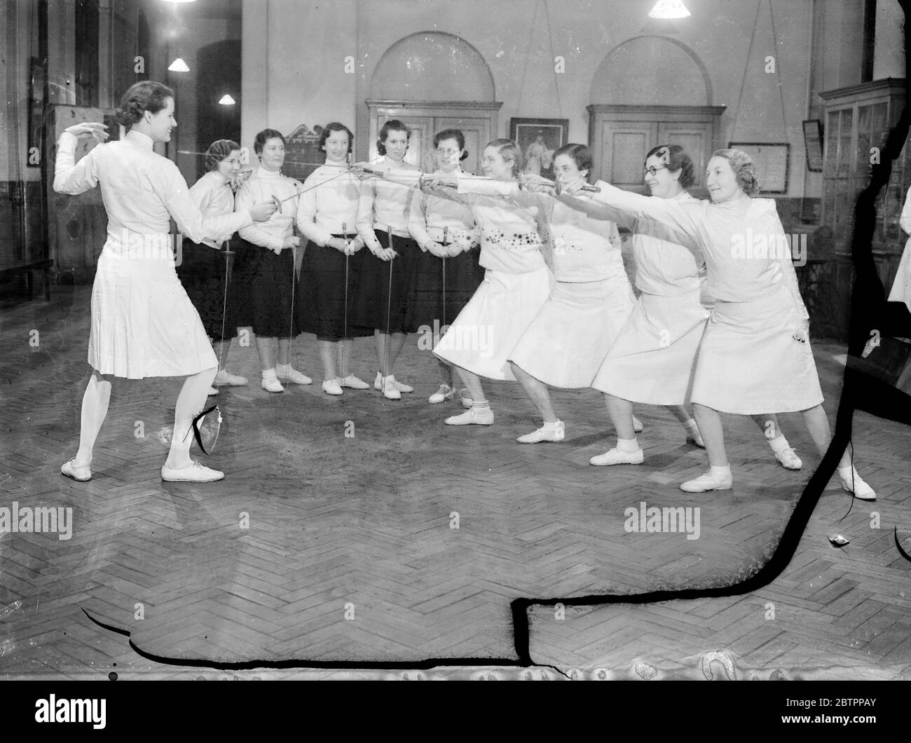 Pointing the way to fitness. A class of girls under instruction from Miss Eleanor MacDonald, the fencing expert, at the Fairclough Institute in Berner Street, Commercial Road. These girls have taken up fencing as an aid to physical fitness. 6 February 1938 Stock Photo