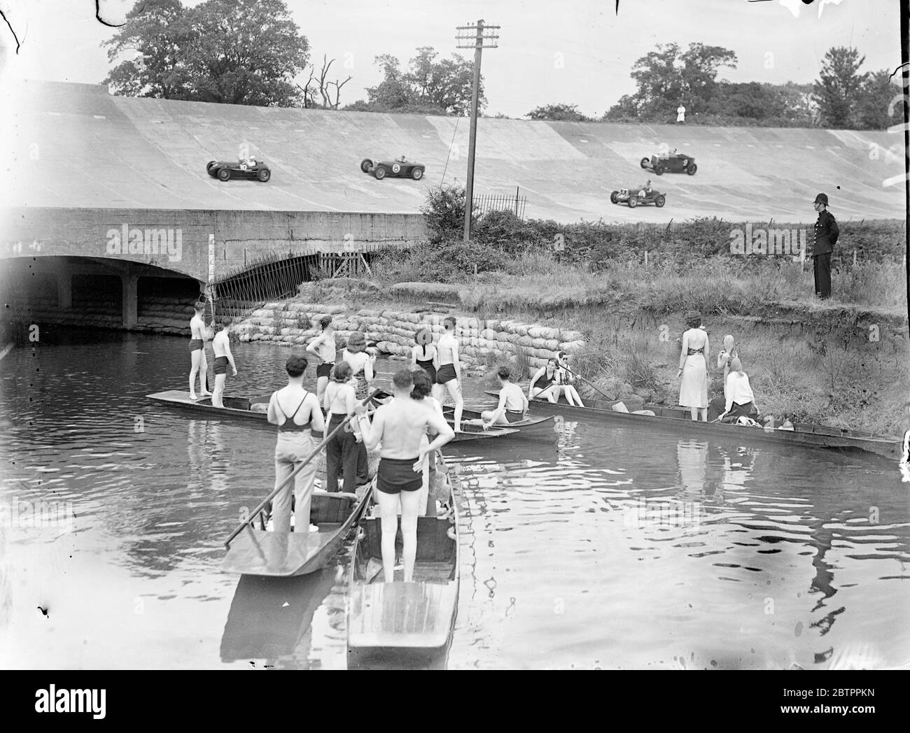 Brooklands thrills seen from punts. Bank Holidaymakers in punts watching cars race around the banking in the August Long Handicap at the Brooklands Bank Holiday meeting. 1 August 1938 Stock Photo