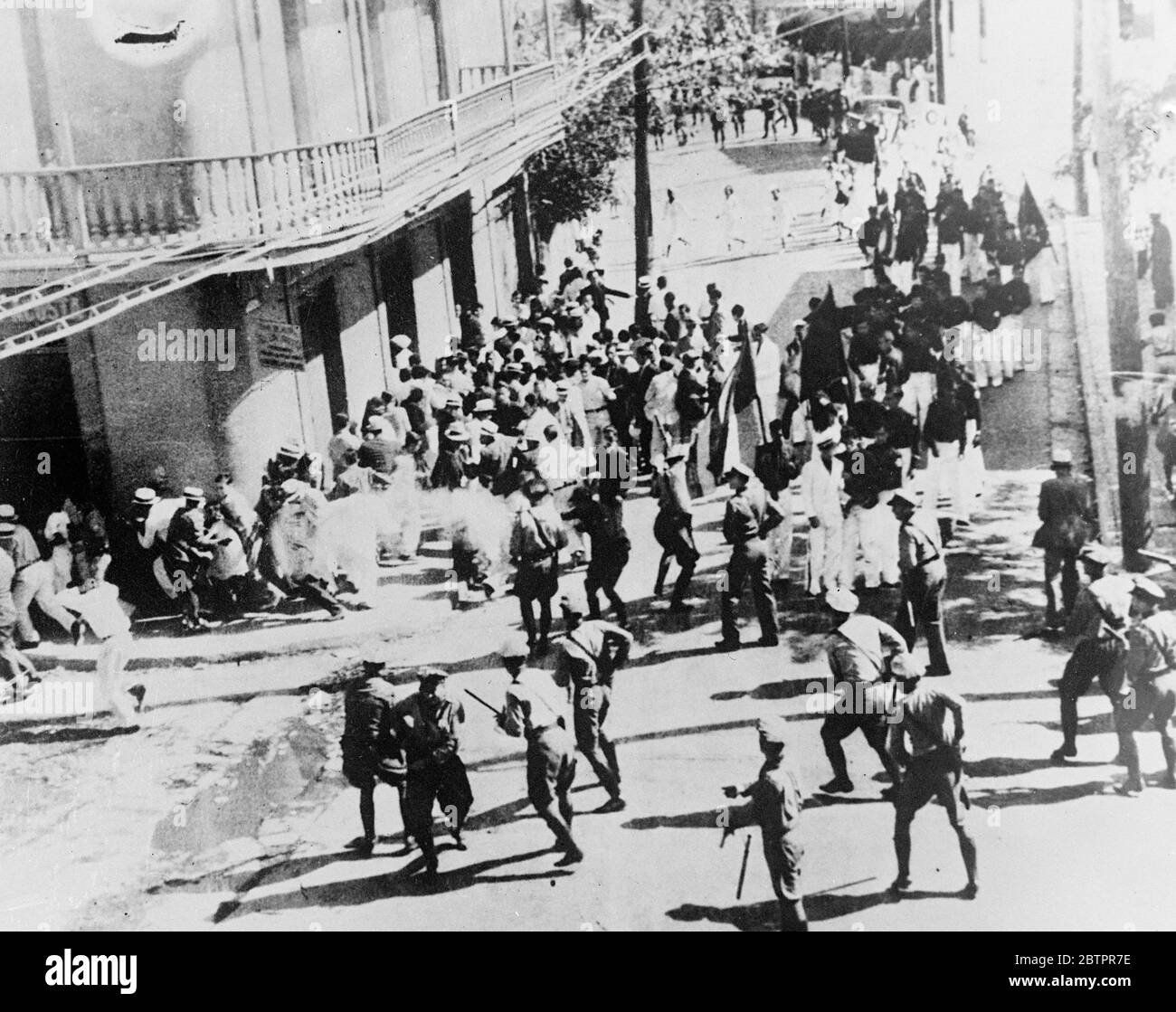 20 killed in 'massacre'. This picture, made in Ponce, Porto Rico, West Indies dependency of the United States, shows the first shots fired in the writing, in which 20 people were killed, when police clashed with members of the Nationalist Party. A policeman who can be seen, although his gun is hidden by another figure, is firing towards a group of fleeing people. Cadets of the Nationalist party are motionless, but girl nurses can be seen running across the street. A report issued by a committee termed the riot and resulting casualties a 'massacre'. 24 June 1937 Stock Photo