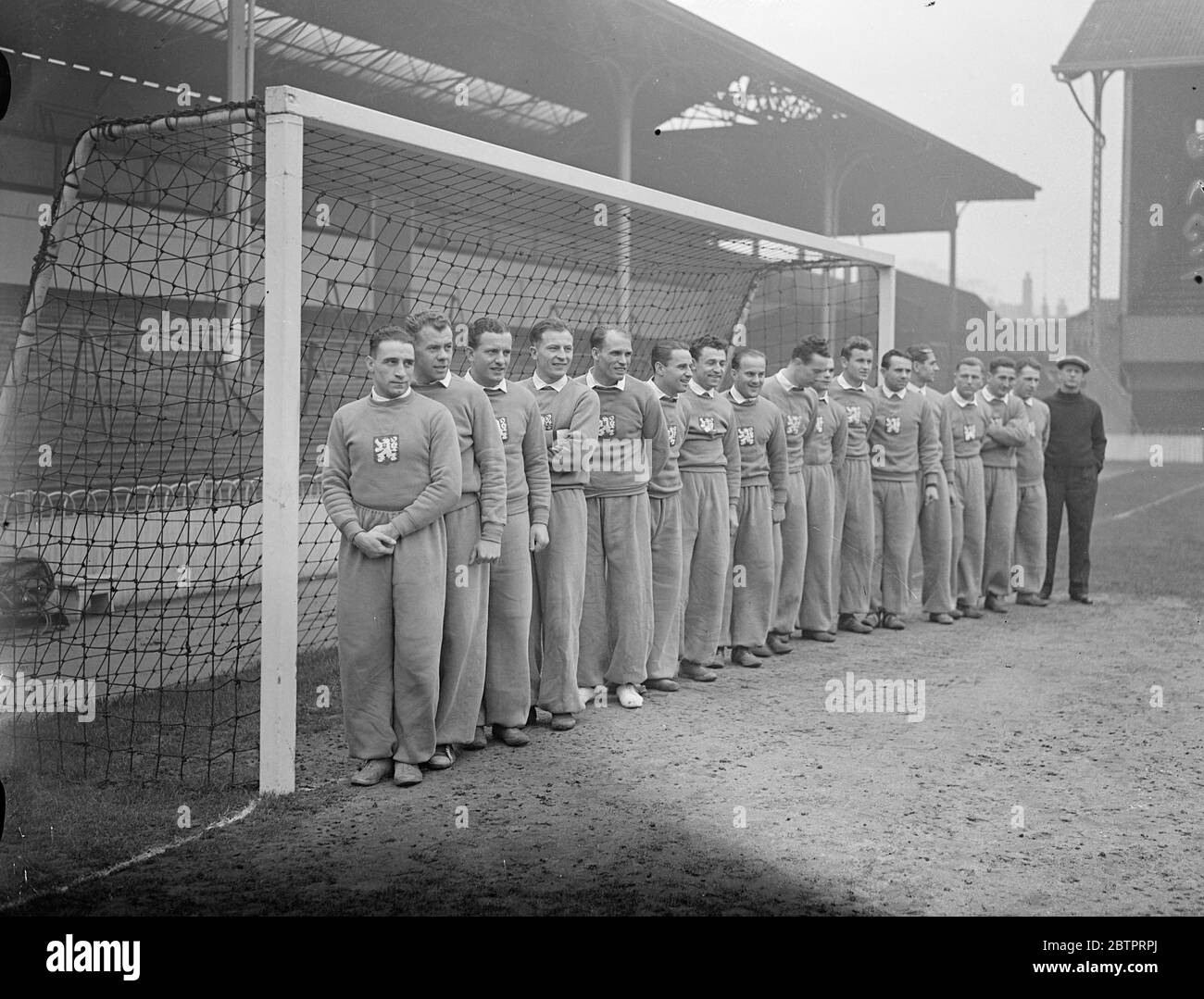 Czech footballers practice at Tottenham. The Czechoslovakian football team which is to meet England in the first international match between the two countries played in Britain, tomorrow (Wednesday), practised at Tottenham Hotspur's ground in White Hart Lane, where the match is to take place. Photo shows, Czech players line up for a team photo. Unknown order, Antonin Puc, Karel Kolsky, Antonin Vodicka, Oldrich Nejedly, Jan Riha, Jaroslav Boucek, Frantisek Planicka (captain), Frantisek Kloz, Josef Zeman, Josef Kostalek, Ferdinand Daucik and the manager Tesar. 30 November 1937 Stock Photo