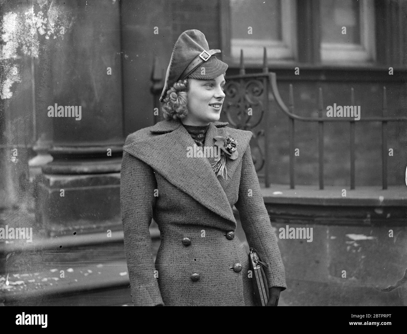 'Apache' touch at London wedding. A distinctive hat, that seams to have a touch of the 'Apache' style, worn by Miss Beatrice Watts at the wedding of Mr G Walker of Sudbury and Miss B Sherman at the Paddington Register office, London. 27 November 1937 Stock Photo