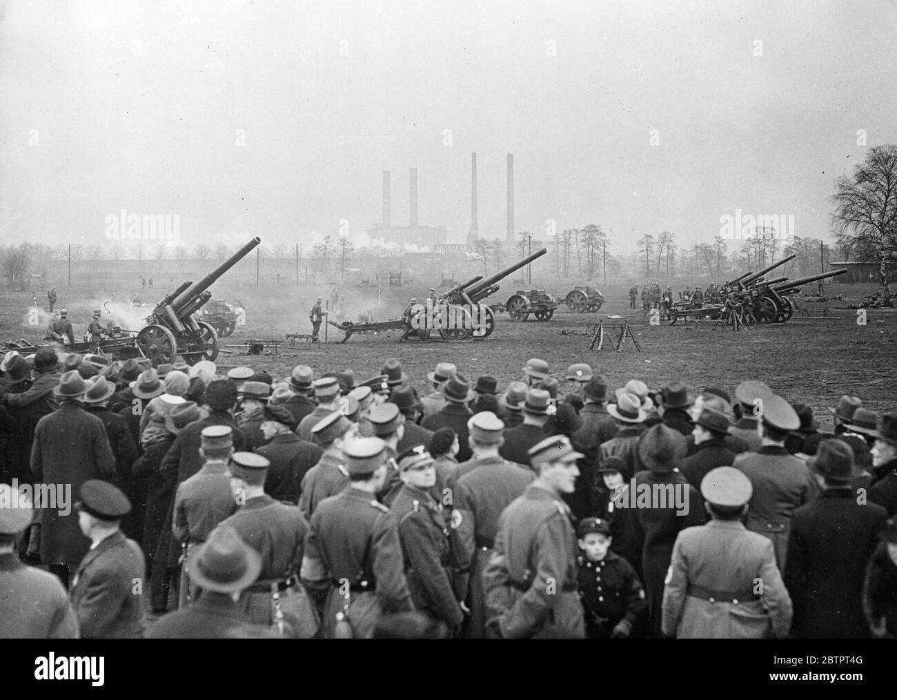 Guns 'collect' for the poor. The German army was mobilised for a day in the service of the Winter Help Scheme. Barracks all over the country were opened to the public to raise funds for winter relief work, and special displays were given by the troops. Photo shows, visitors watching a display by big guns in Ruhleben. 6 December 1937 Stock Photo