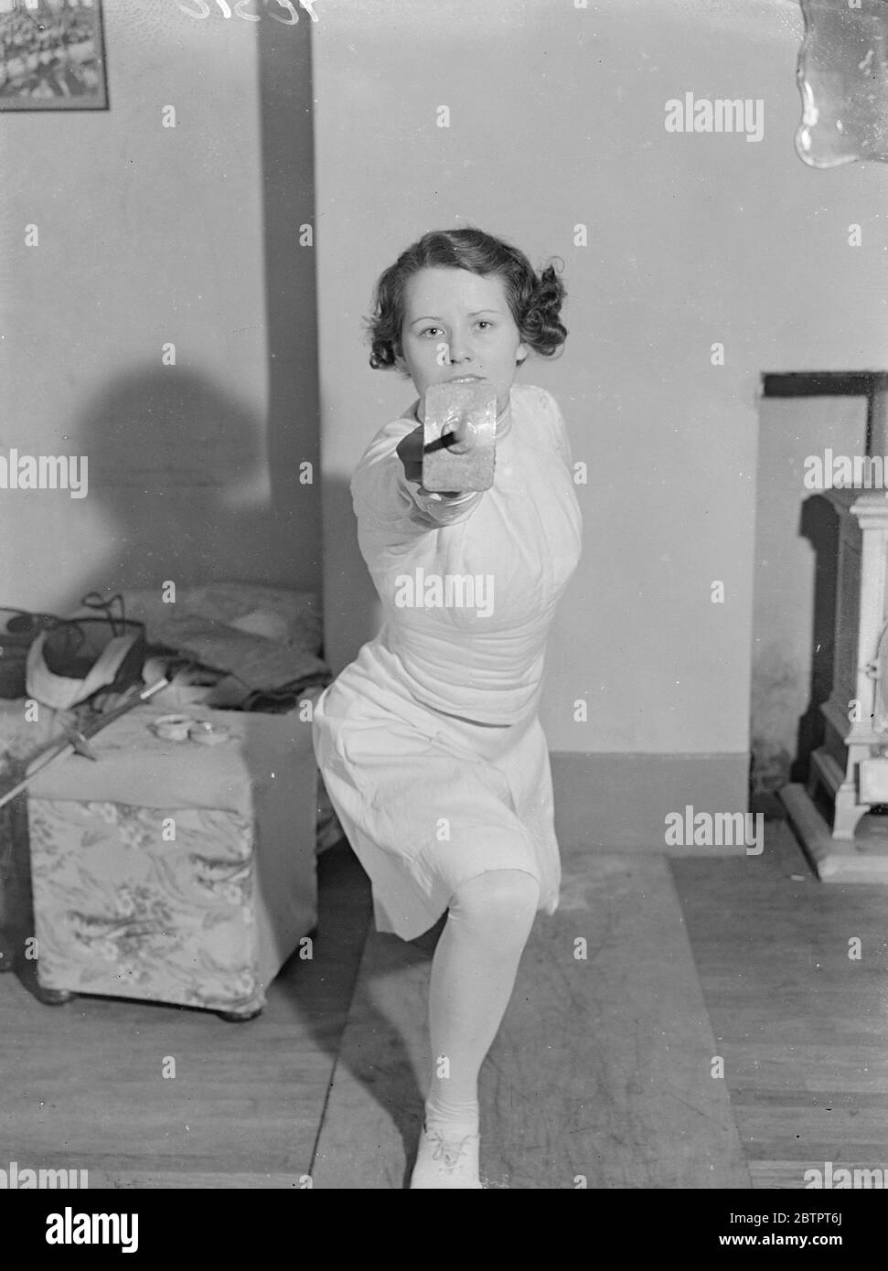 Straight to the point. Miss Eleanor MacDonald, 27-year-old fencing expert and teacher, and the only English woman to hold the highest French award for fencing, is busily training. 12 entrants for the junior fencing Championships, the finals of which will be held in London tomorrow (Friday). Photo shows, an opponent's eye view of Miss Ellen McDonald. 15 October 1937 Stock Photo