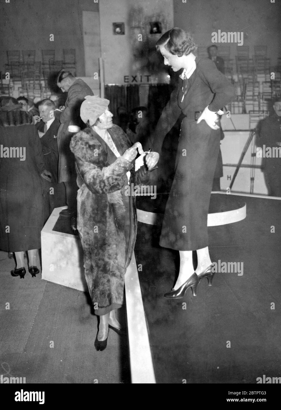 British Industries Fair at White City. Miss F. Horsburgh, M.P. (Dundee) inspecting one of the dresses worn by a mannequin in the fashion section. 27 February 1935 Stock Photo
