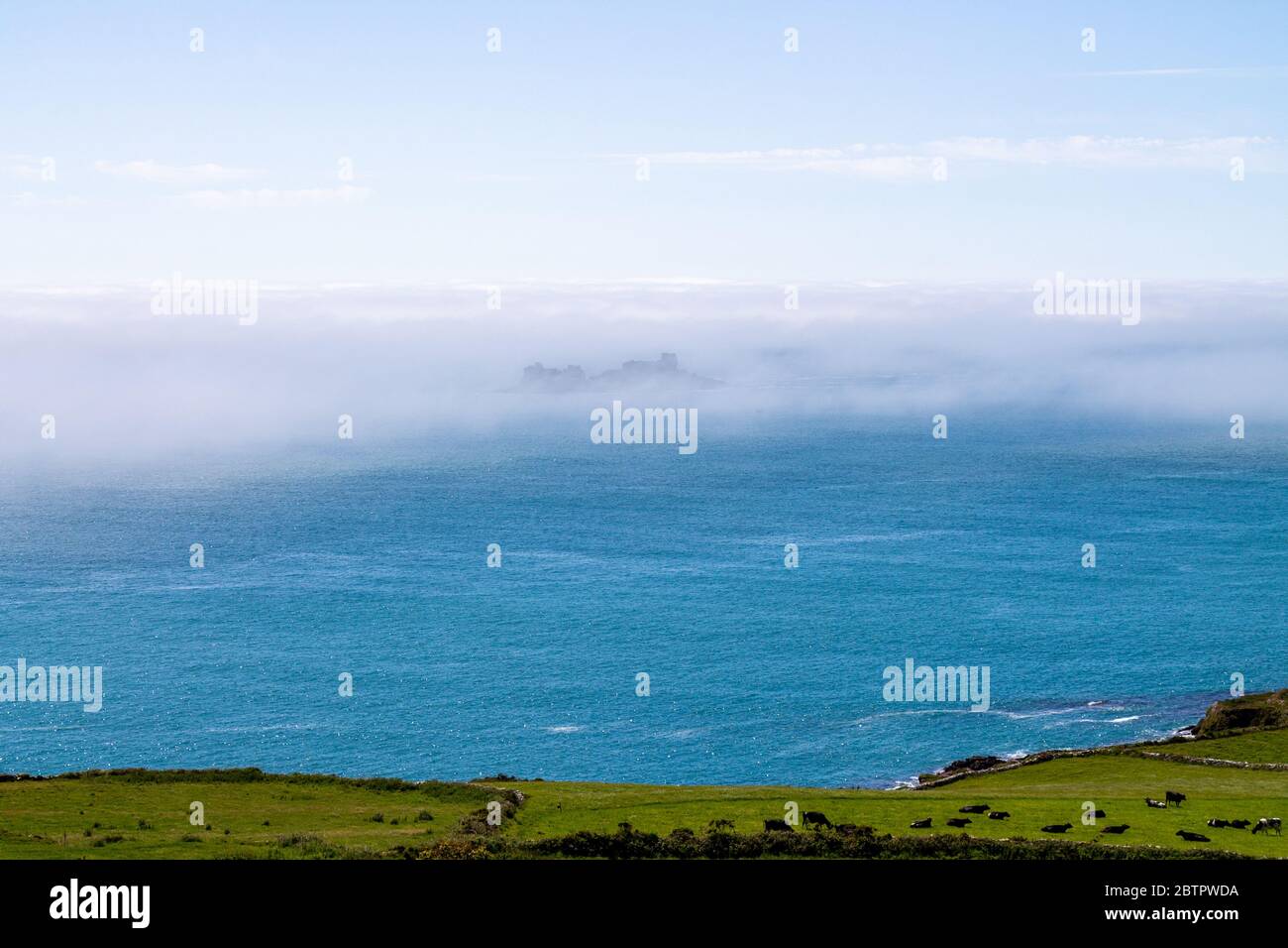 Sea mist or fog bank drifting over the coast. Stock Photo