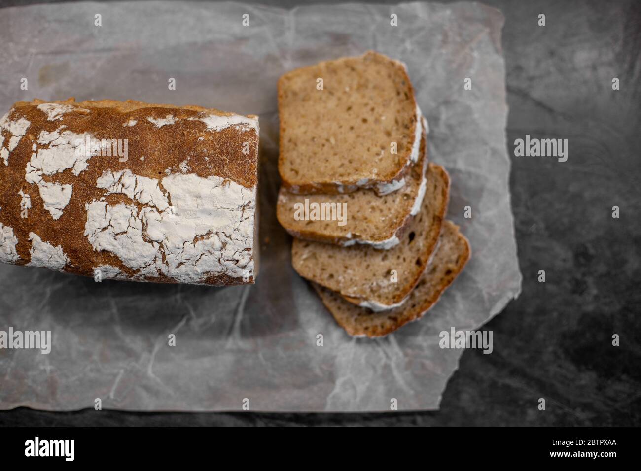 Fragrant and crunchy sliced bread on parchment in the kitchen. Homemade