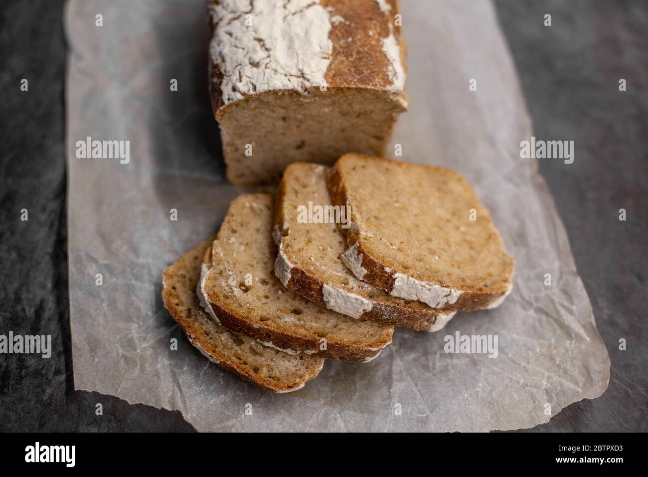 Fragrant and crunchy sliced bread on parchment in the kitchen. Homemade