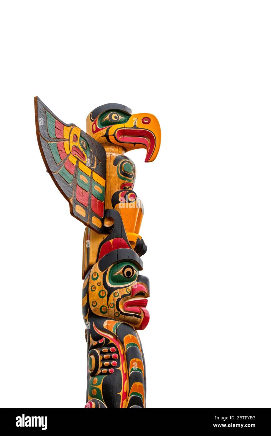 Colourful wooden carved Canadian totem pole against white background Stock Photo