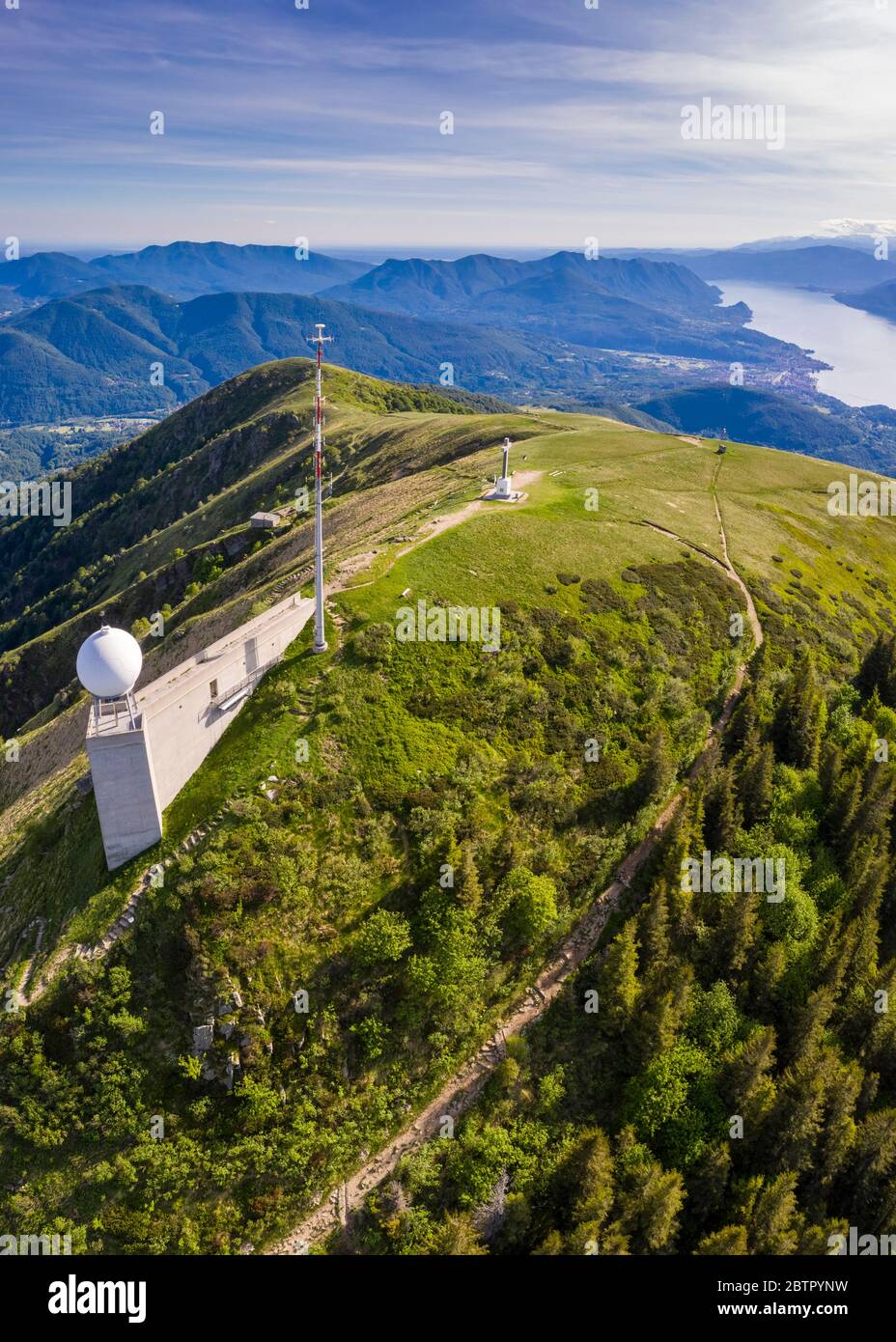 Aerial view from the top of Monte Lema towards Lake Maggiore with its cableway and refuge. Lugano Prealps, Canton Ticino, Switzerland. Stock Photo