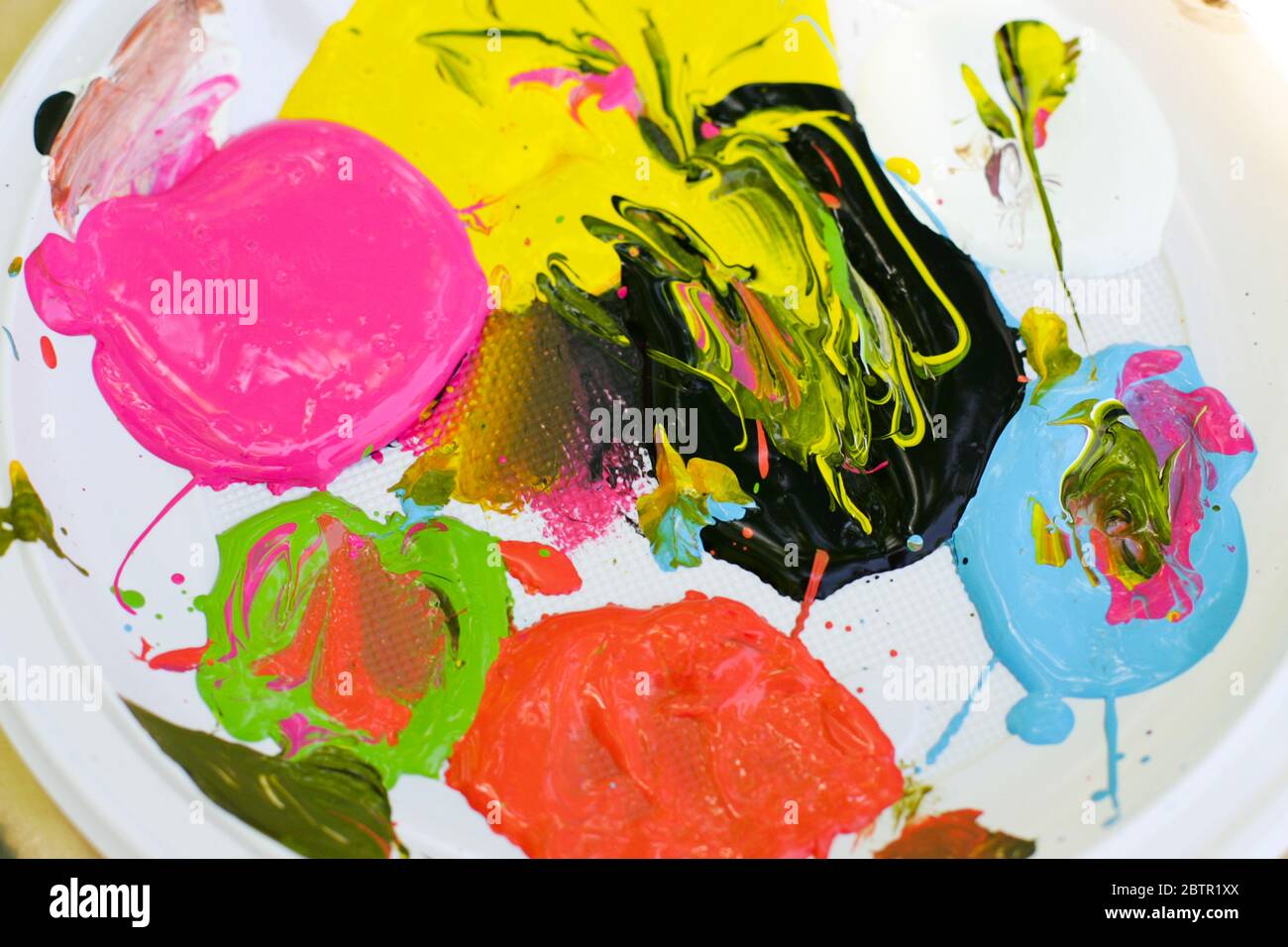 Mixing paint creates colorful abstract shapes.. Stock Photo