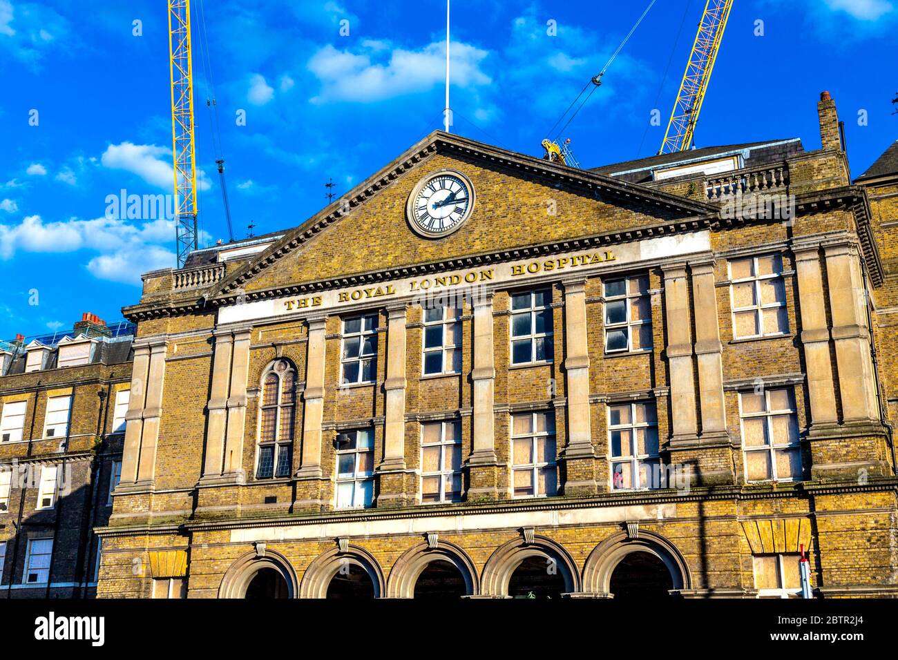 Facade of the old Royal London Hospital building with clock, currently being converted into a new civic centre for Tower Hamlets Council, London, UK Stock Photo
