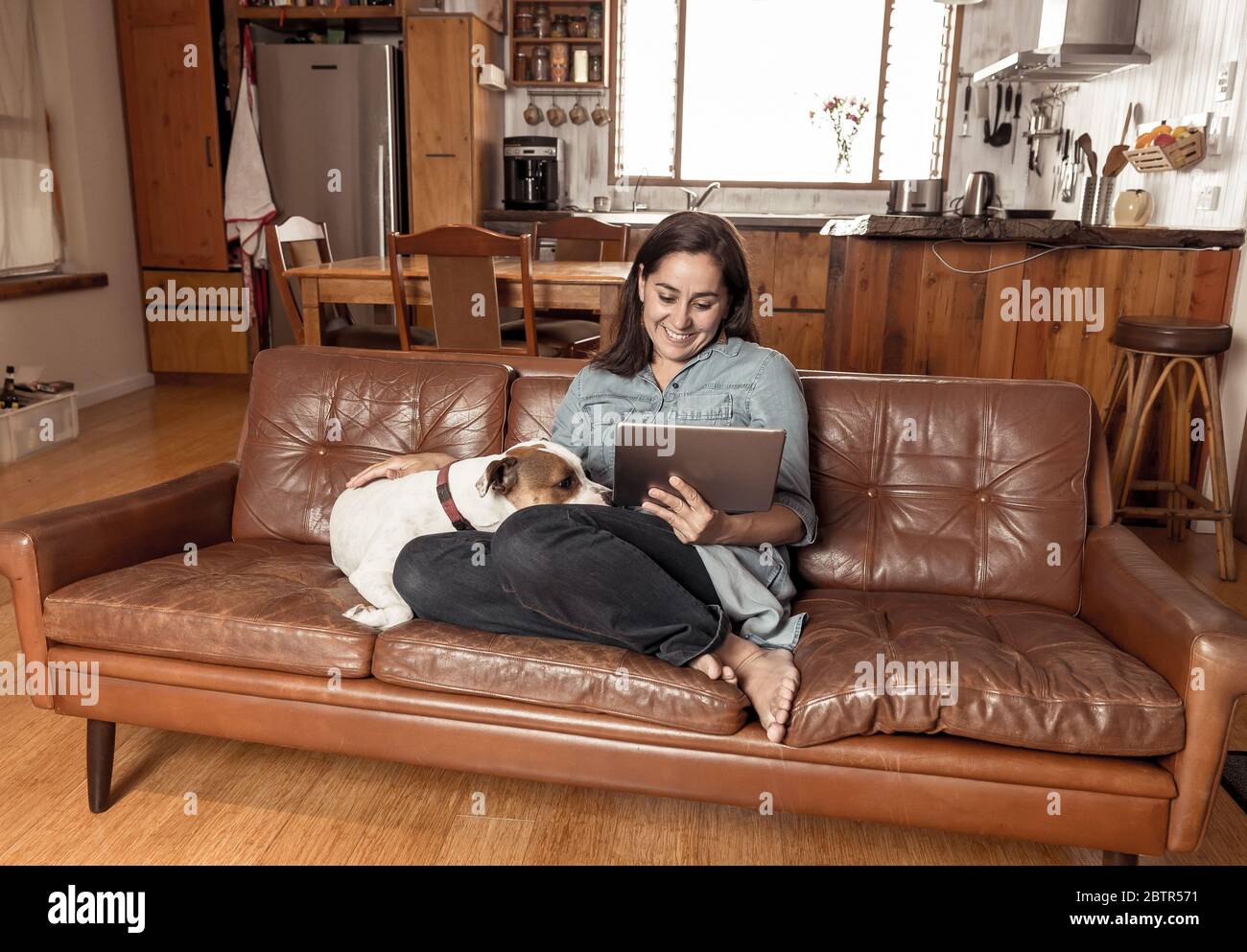 Working from home. Woman on sofa with cute pet dog using laptop on video  conference with work team during coronavirus Outbreak and social distancing  Stock Photo - Alamy
