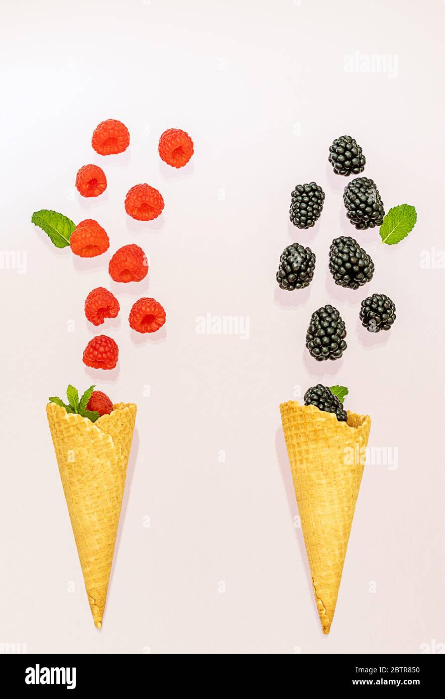 Raspberry and blackberry fallen in two ice cream cones. Summer concept. Stock Photo
