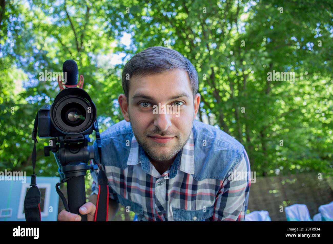 man in a shirt with a monopod and a camera Stock Photo Alamy