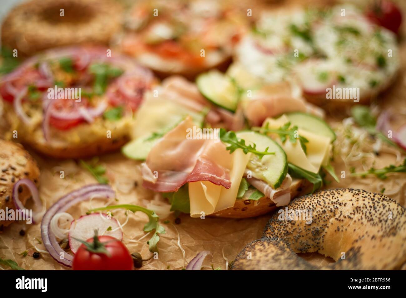 Composition of various homemade bagels sandwiches with sesame and poppy