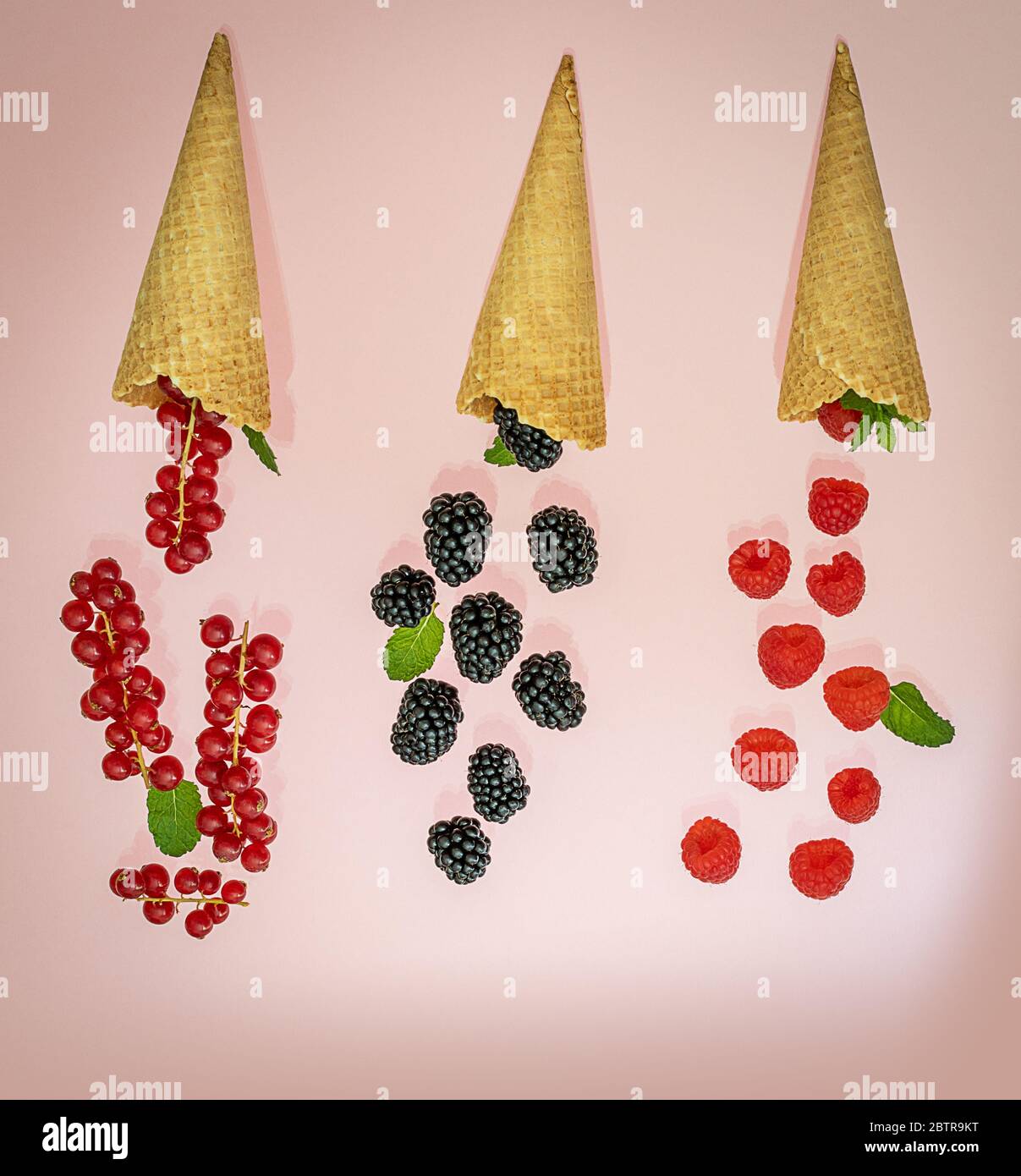 Flipped ice cream cones with various berries. Summer concept. Stock Photo