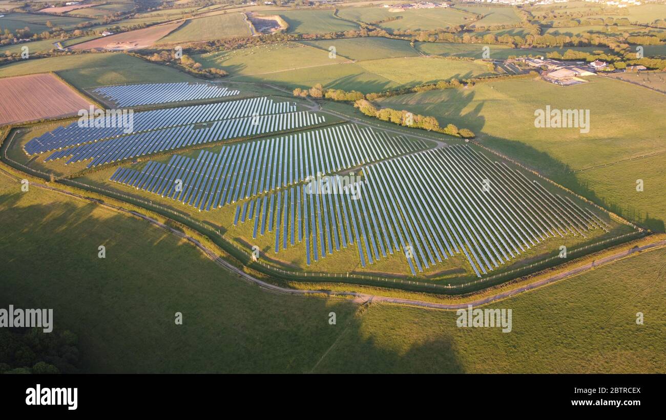 Photovoltaic power station. Solar farm solar panels on green fields, farmland, transforming solar light into electricity Haverfordwest, Pembrokeshire Stock Photo
