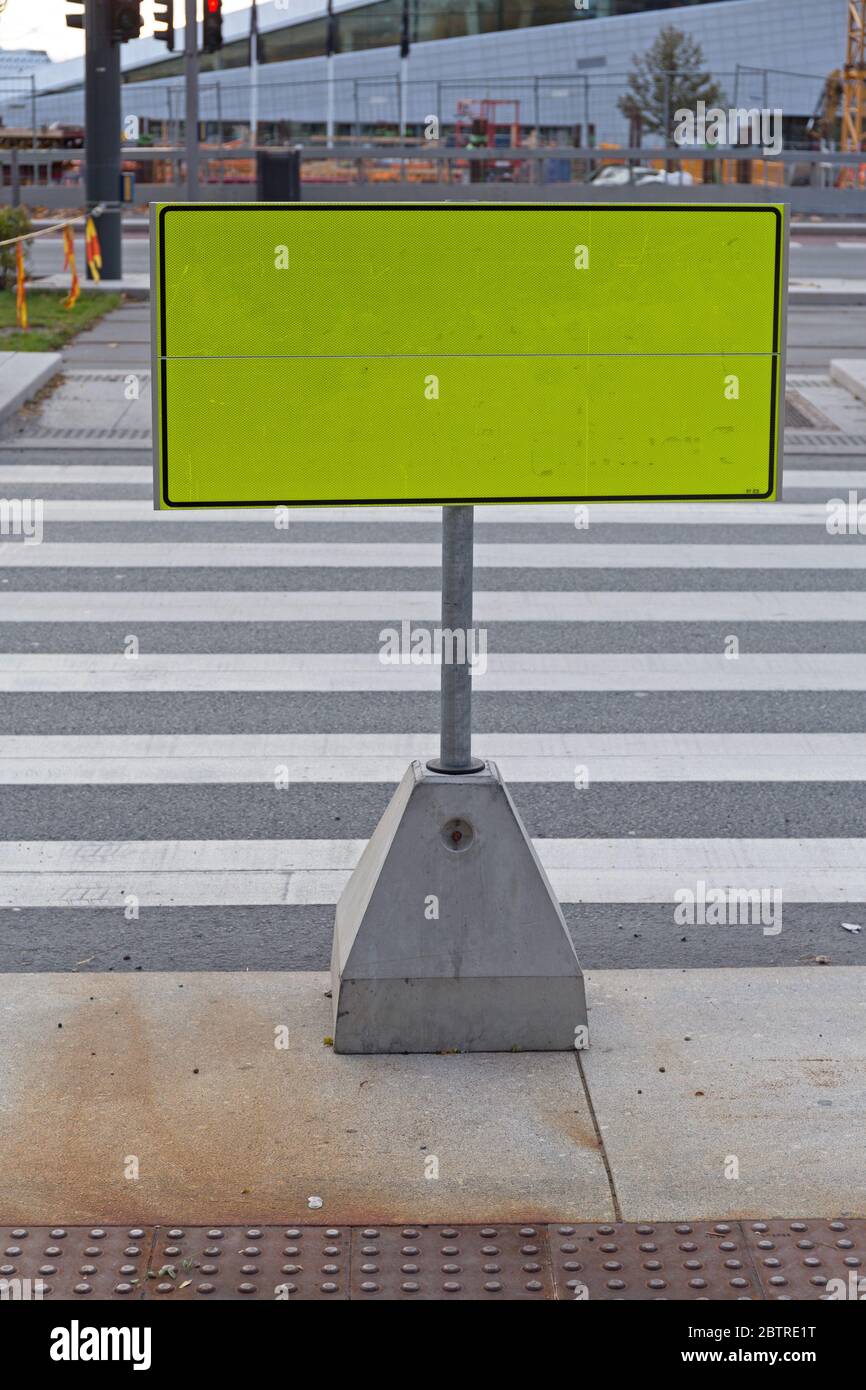 Big Yellow Caution SIgn Board at Street Crossing Stock Photo
