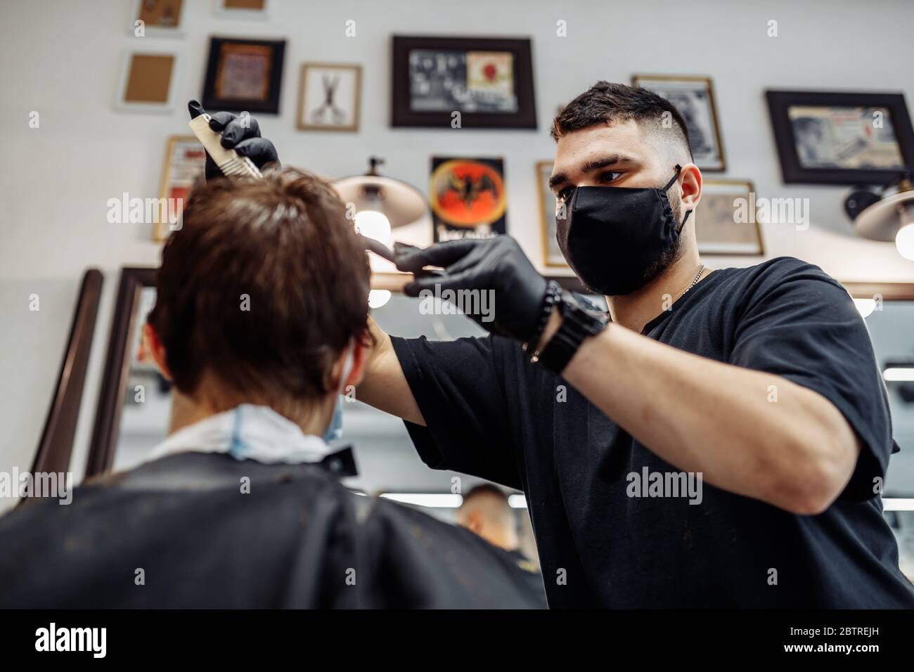 Professional barber makes hairstyle young hi-res stock photography and ...