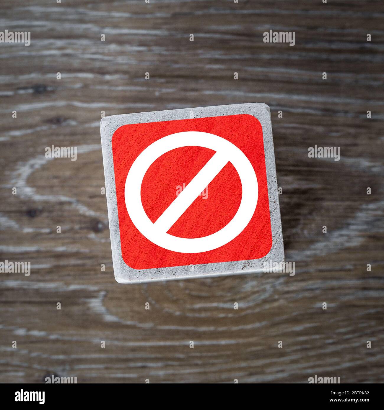 A red stop sign, symbol or icon on a wooden block and wood background with copy space Stock Photo