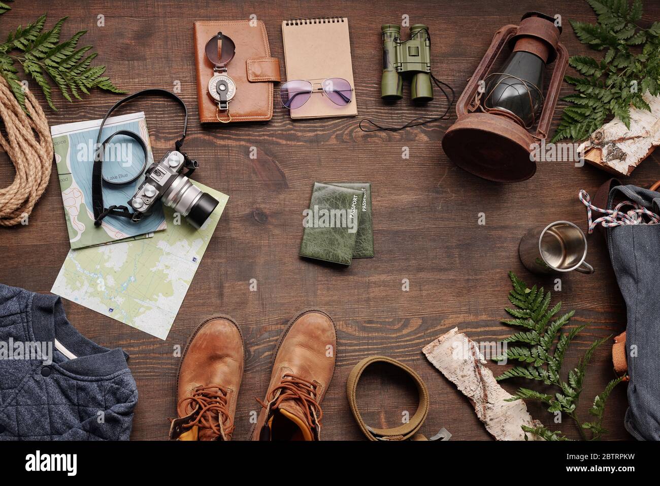 Above view of forest hiking stuff on dark wooden table for travelling abroad, flat lay Stock Photo