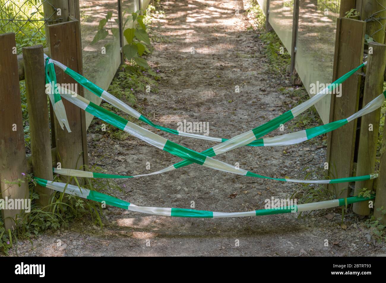 During Corona no entrance through a path. It is closed by a barrier tape Stock Photo