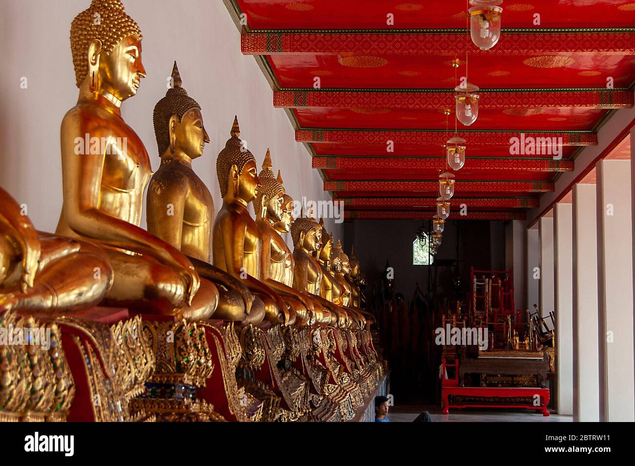 A row of seated golden Buddhas at Wat Pho, Bangkok, Thailand. Stock Photo