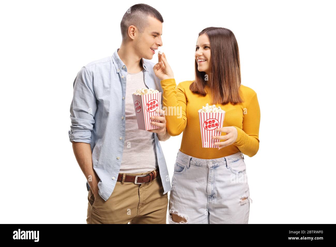 Girlfriend giving popcorn to a boyfriend isolated on white background