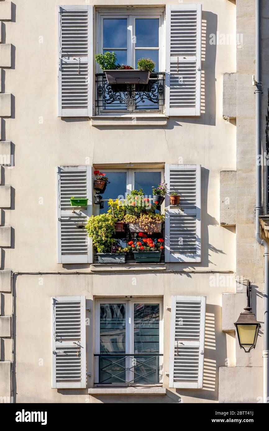 Paris, France - May 14, 2020: Window with flowers in a parisian house Stock Photo