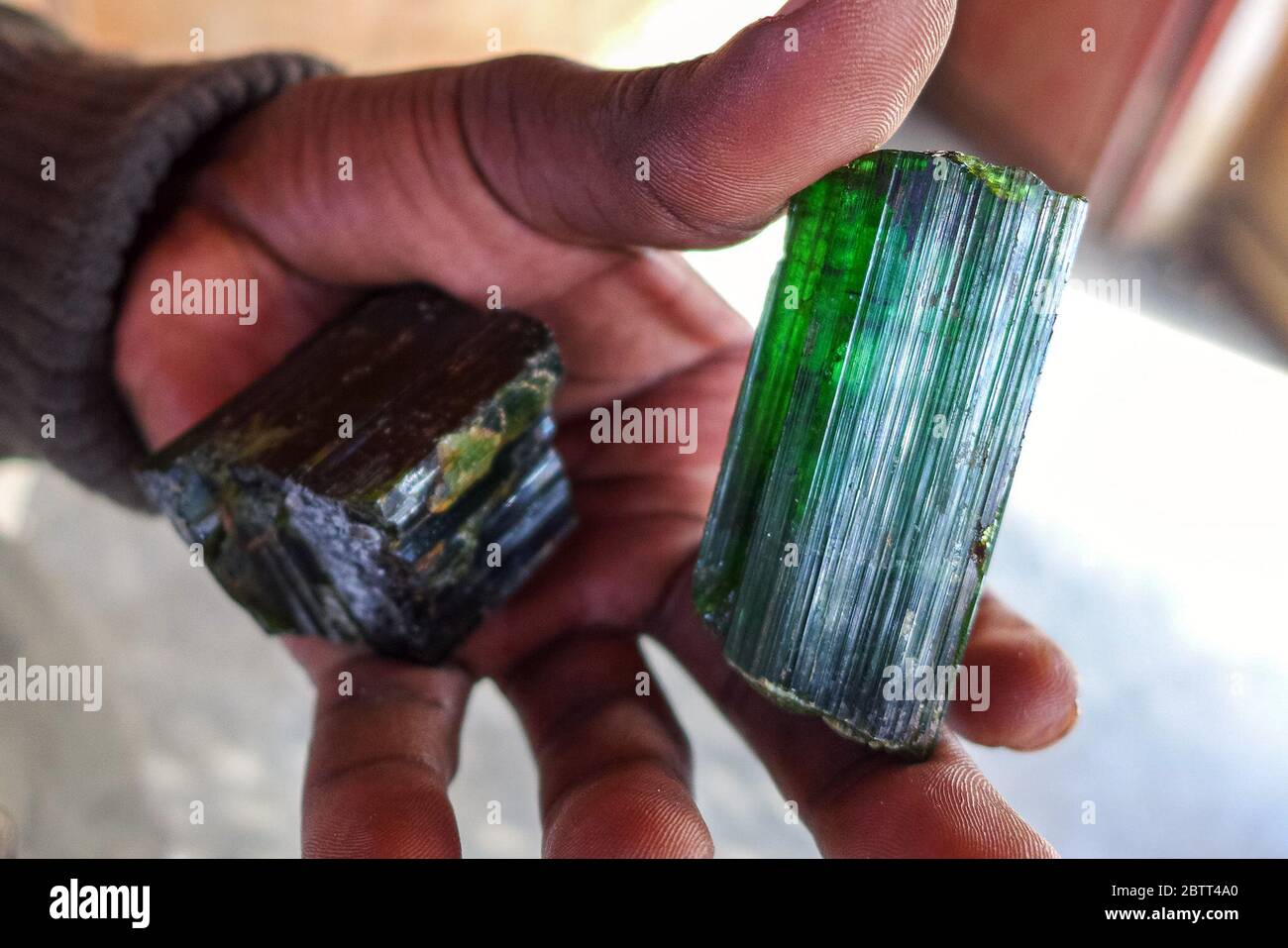 A smuggler displays tourmaline, an ore that’s highly sought by mineral traffickers. A gram can cost between $20 and $150, depending on the volume and quality of the stones. (Noella Nyirabihogo, GPJ Democratic Republic of Congo) Stock Photo
