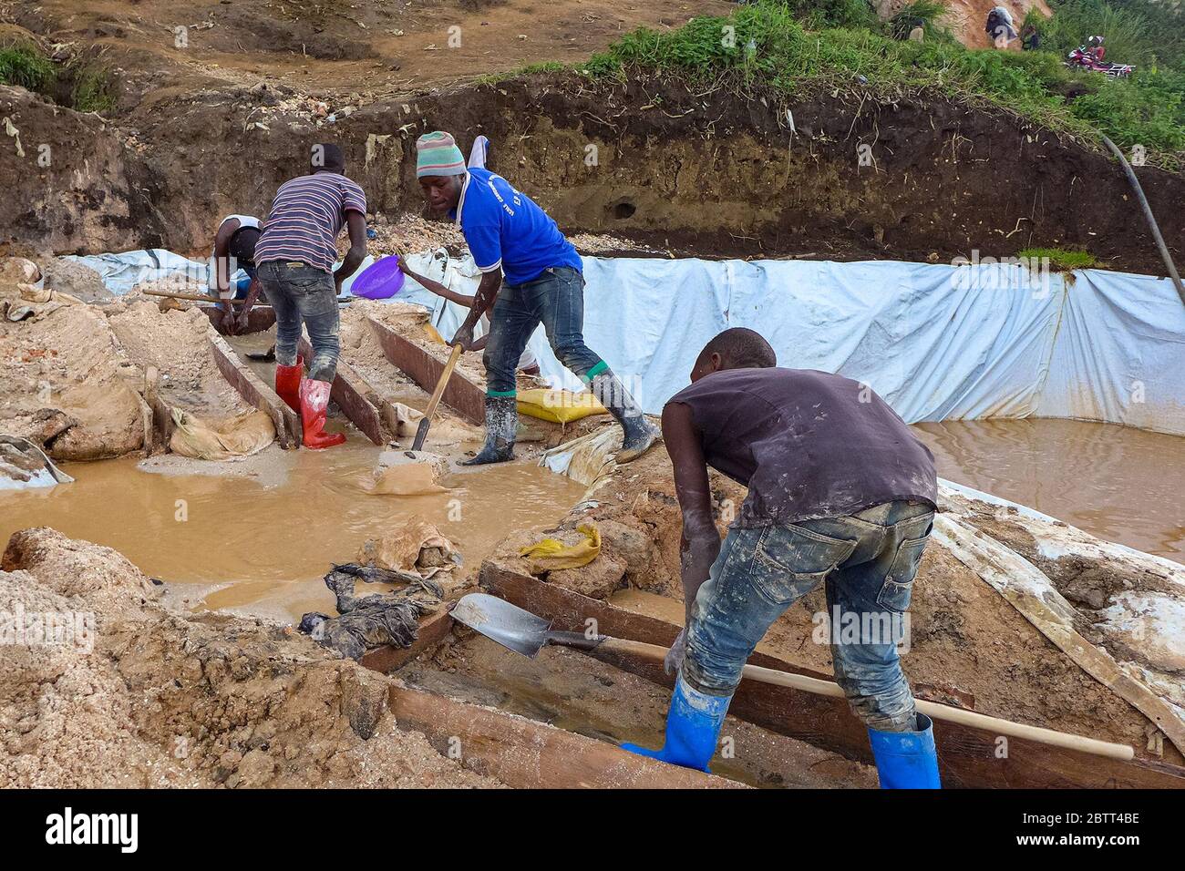 Using water and a basin, Rubaya miners separate sand from coltan, a necessary step in getting the mineral ready for sale. (Noella Nyirabihogo, GPJ Democratic Republic of Congo) Stock Photo