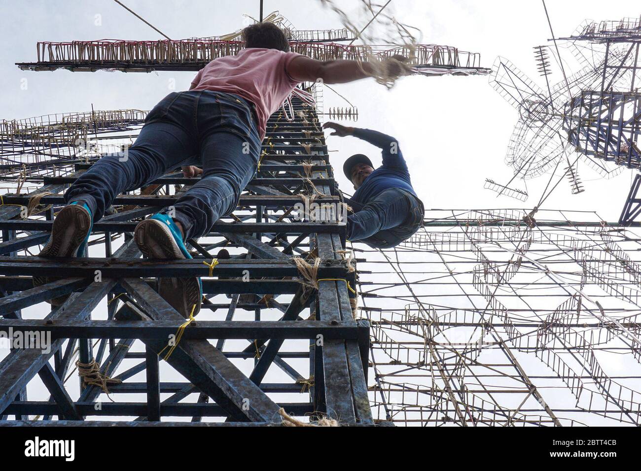 Ángel González, 19 (left), and Javier Hernández, 25, climb a tower on a pyrotechnic castle, a wooden structure used for celebrations in Mexico City. When the gunpowder lights on the castles are ignited, they create the silhouette of a brilliantly lit castle for a few minutes. “Making pyrotechnic castles is what I like to do the most,” says González, who has worked on their construction for five years. (Mar Garcia, GPJ Mexico) Stock Photo