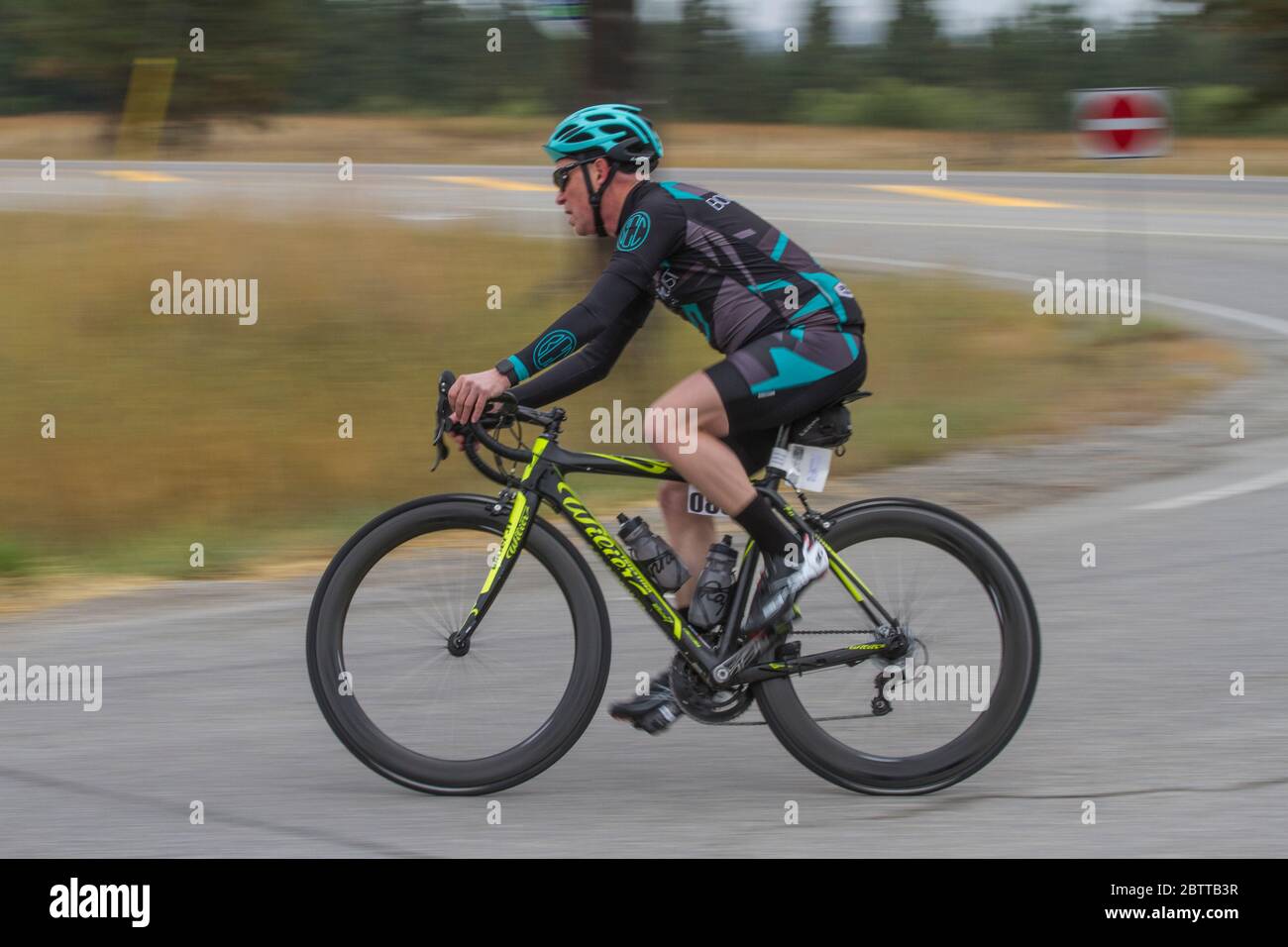 Scenic Bike Race, single rider, in full racing gear and uniform, taking corner Stock Photo