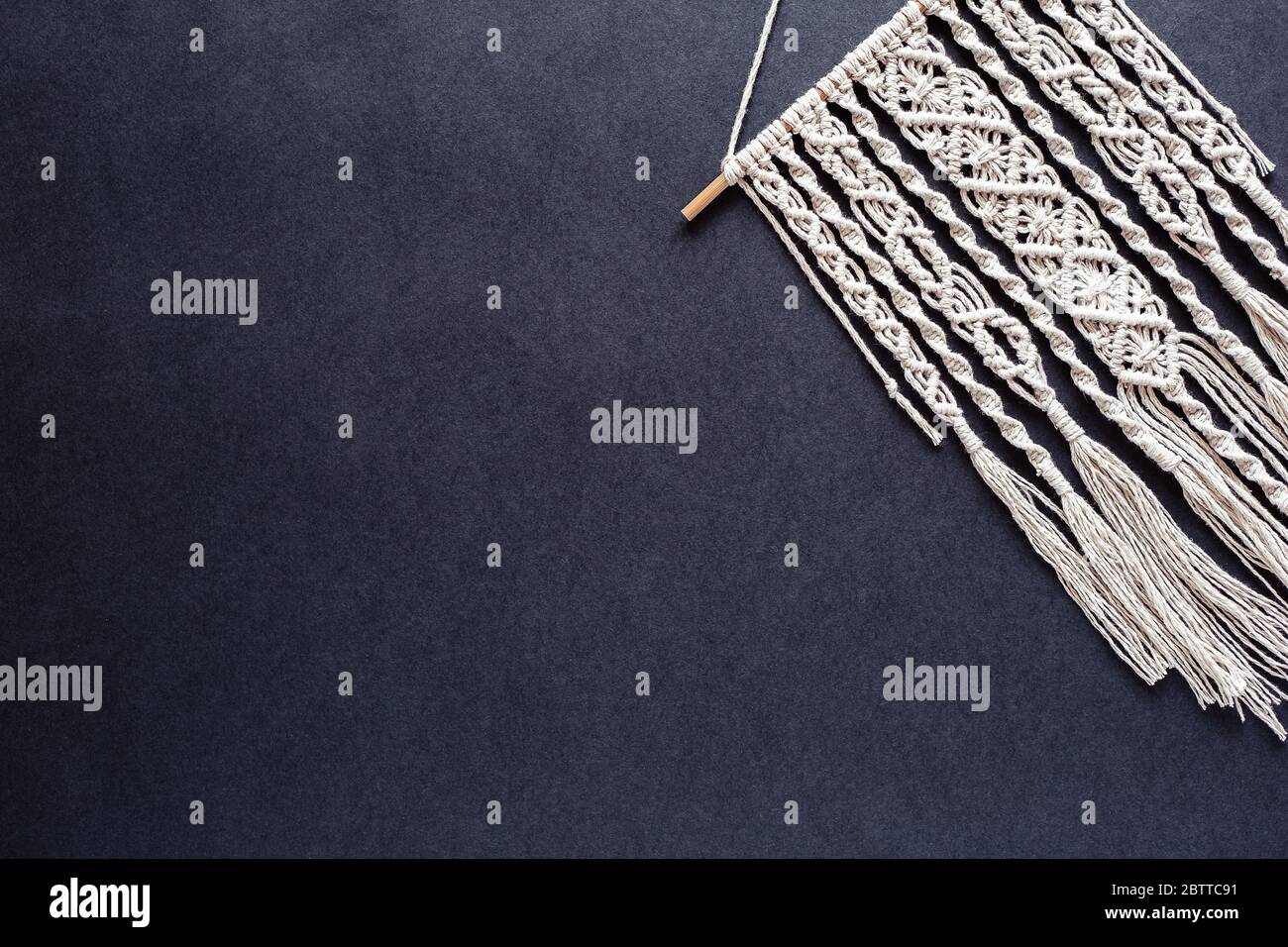Hand woven black macrame with white beads hanging on wall Stock Photo -  Alamy