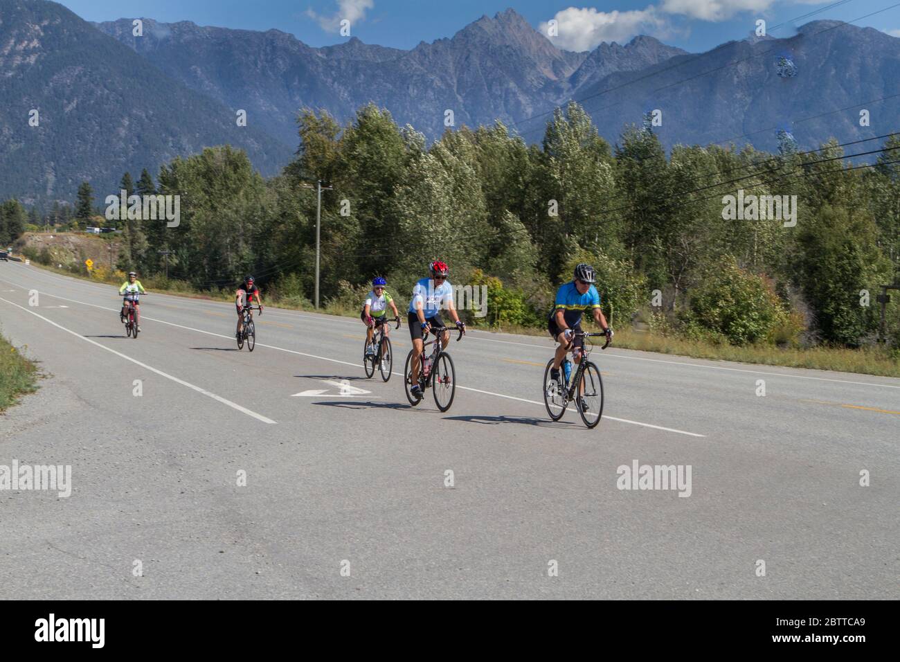 Scenic Bike Race, 2 riders, in full racing gear and uniform. Race goes thru farmland and the mountains. Stock Photo
