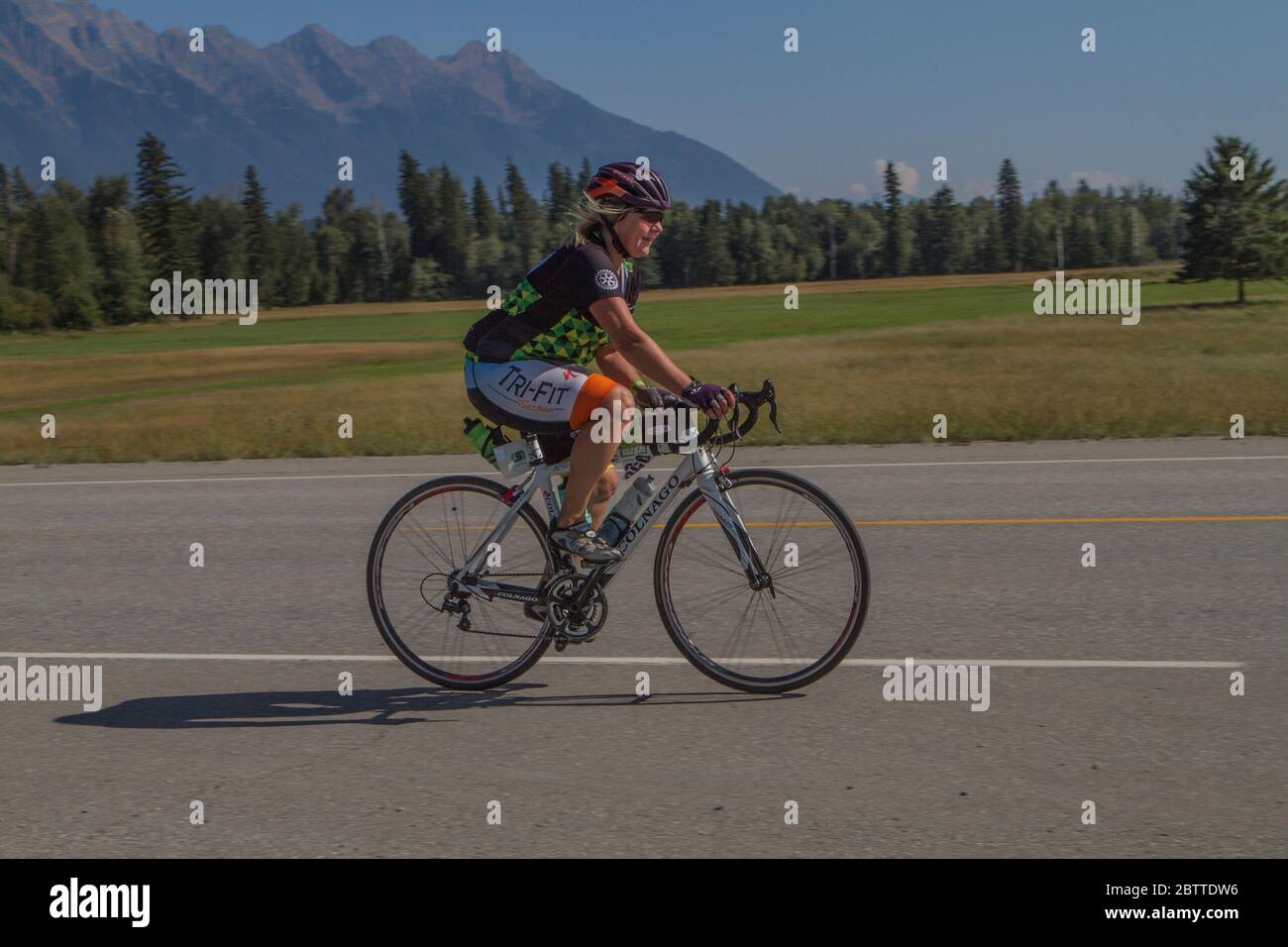 Scenic Bike Race, single rider, in full racing gear and uniform. Mountain background Stock Photo