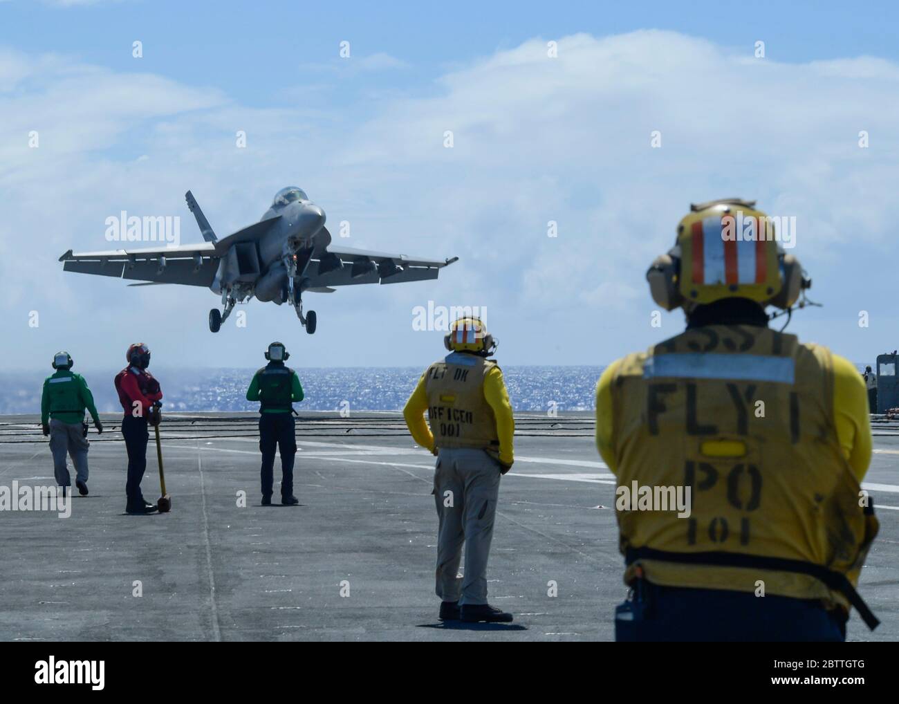 A U.S. Navy F/A-18F Super Hornet fighter aircraft, assigned to the Black Knights of VFA 154, approaches to land on the flight deck of the Nimitz-class aircraft carrier USS Theodore Roosevelt May 26, 2020 in the Philippine Sea. The COVID-negative crew returned from quarantine and the ship has continued their scheduled deployment to the Indo-Pacific. Stock Photo
