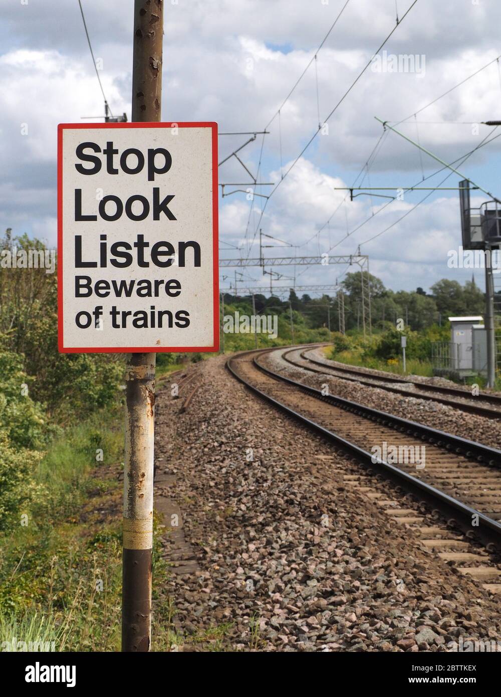 Warning Sign at a Foot Level Crossing on the Northampton Loop of the West Coast Maine Line near Northampton. Stop, Look, Listen Beware of Trains Stock Photo