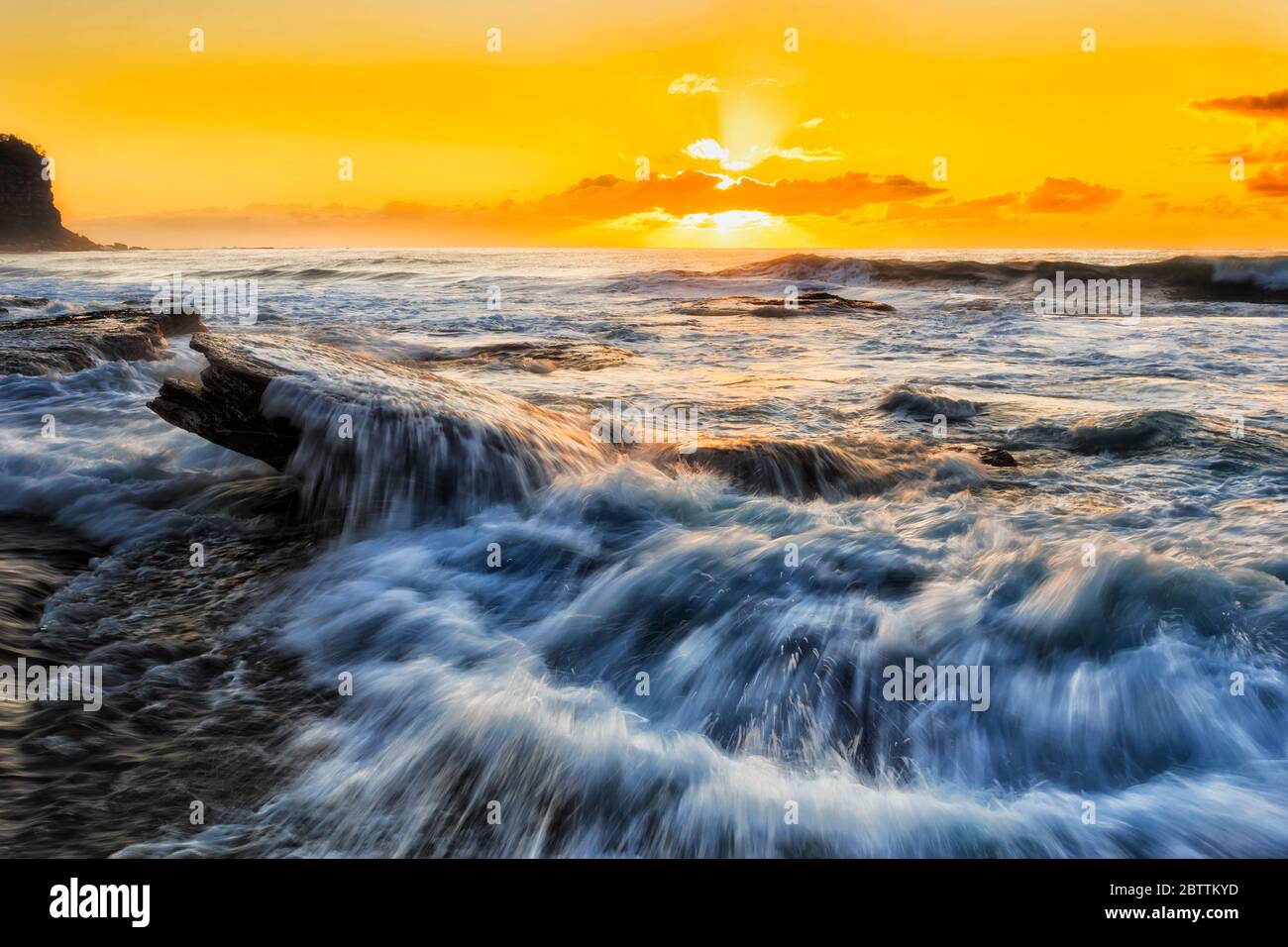 Bright orange seascape sunrise over Pacific ocean horizon from Northern beaches in Sydney. Stock Photo