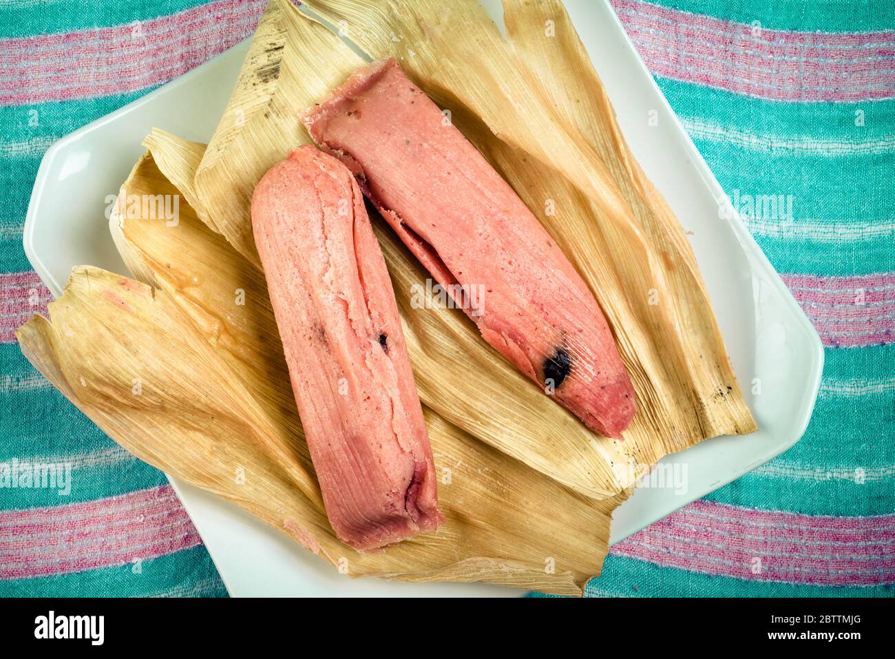 Sweet Tamale, Mexican dish made with corn dough with raisin and strawberry  or pineapple flavored, wrapped with a corn leaf Stock Photo - Alamy