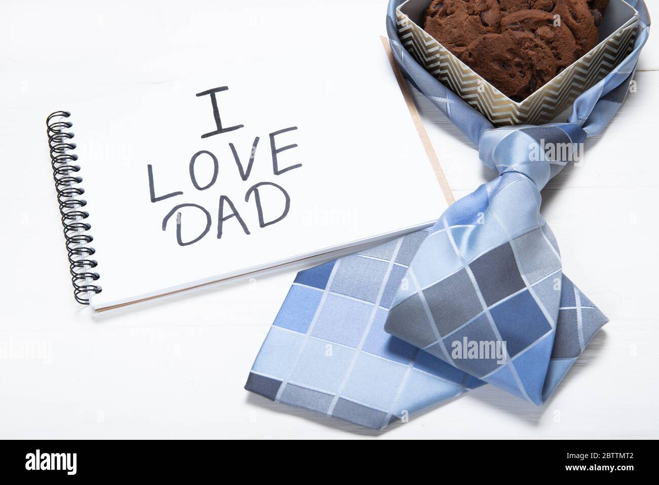 Notepad with text i love dad and a box with cookies. Daddy's Day Holiday Concept Stock Photo