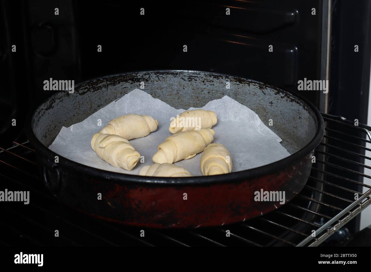 Unbaked rolls in a casserole and ready for backing in the oven. The process of preparing homemade rolls pastry. Domestic and hand made food Stock Photo